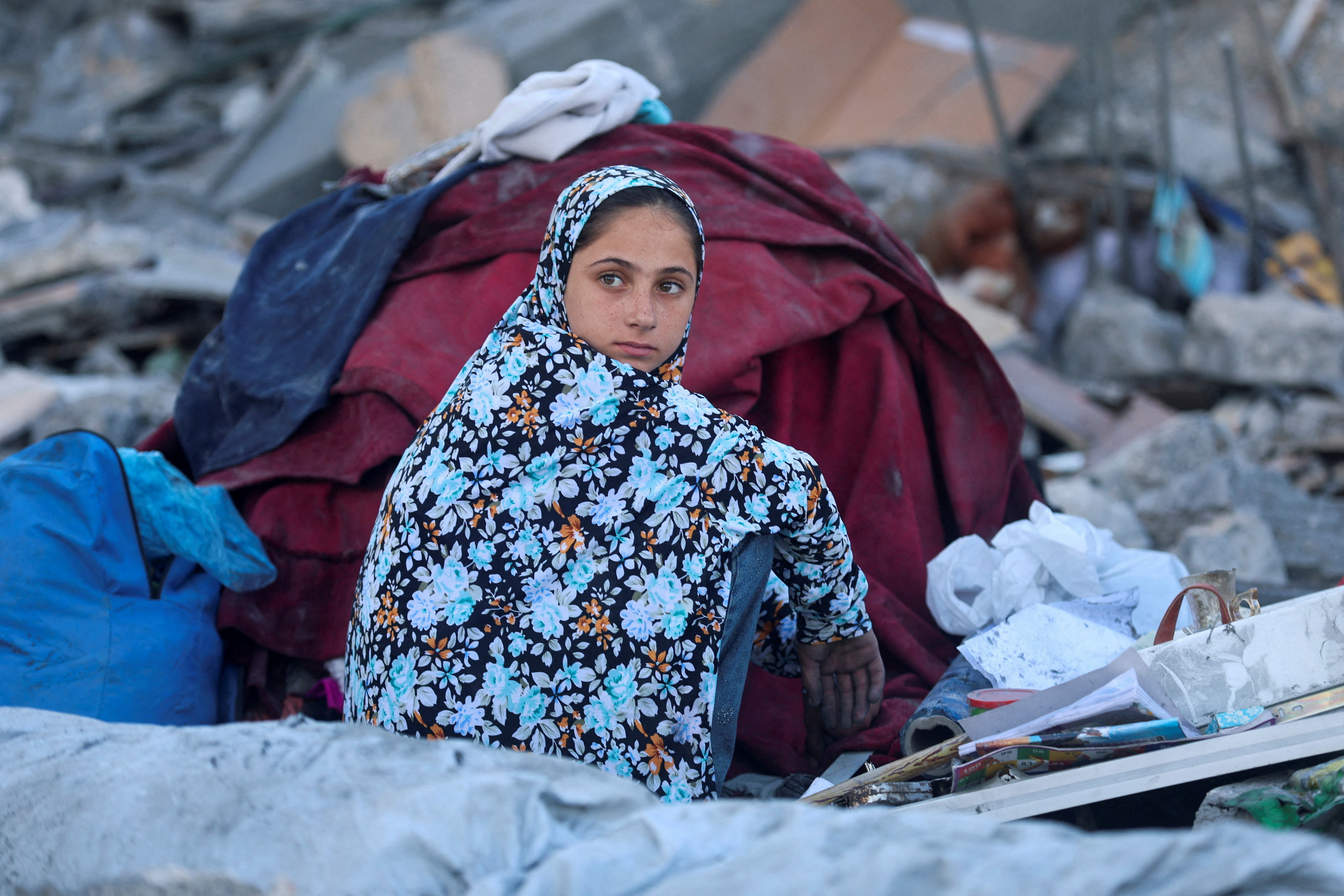 A Palestinians girl sits at the site of an Israeli strike on a house whose residents were warned to evacuate before the attack