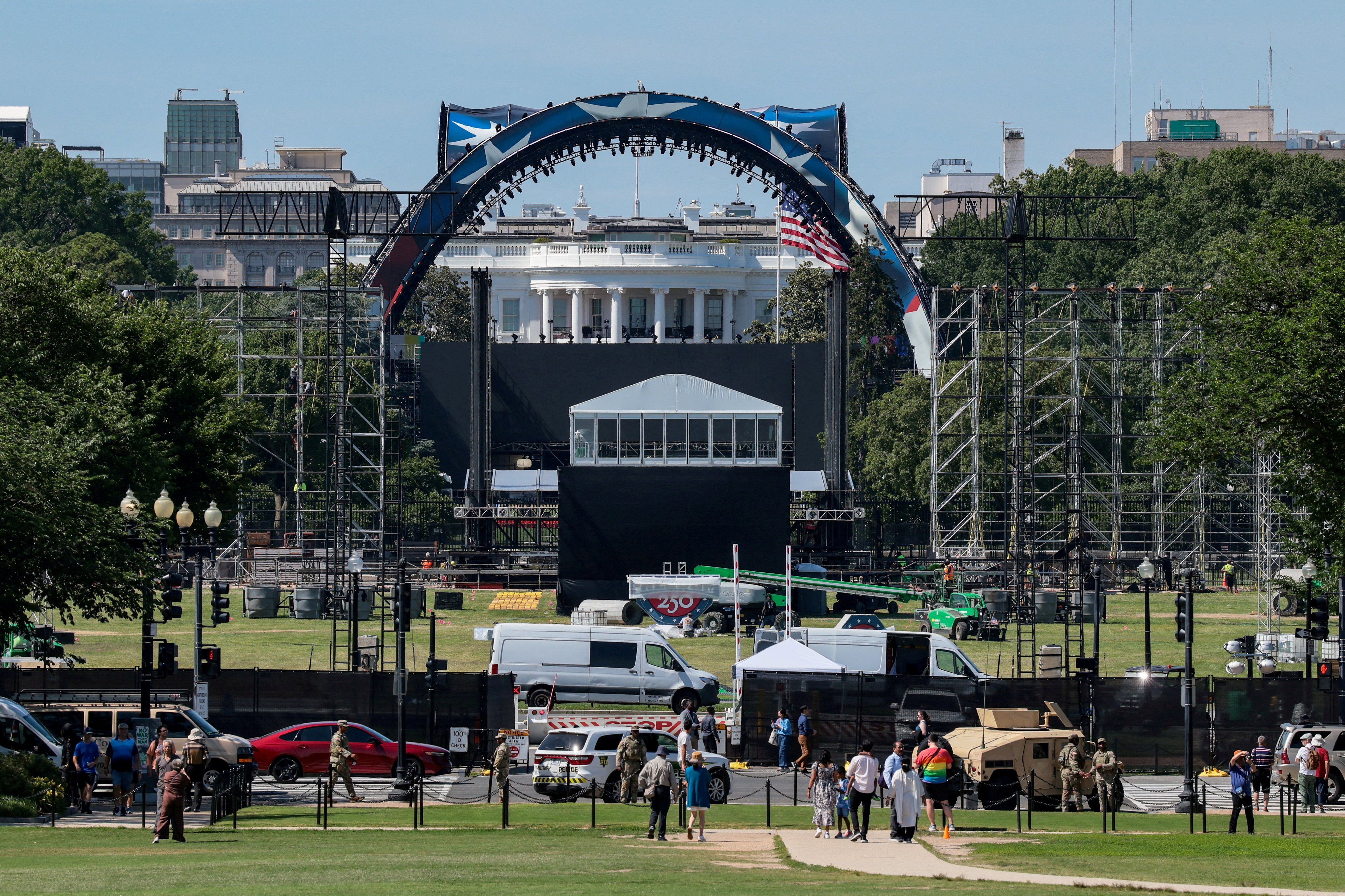 FILE PHOTO: People walk and stand nearby as construction continues on the Ellipse and a temporary arena for the UFC Freedom 250 fight card at the White House in Washington, D.C., U.S., June 5, 2026. REUTERS/Kylie Cooper/File Photo