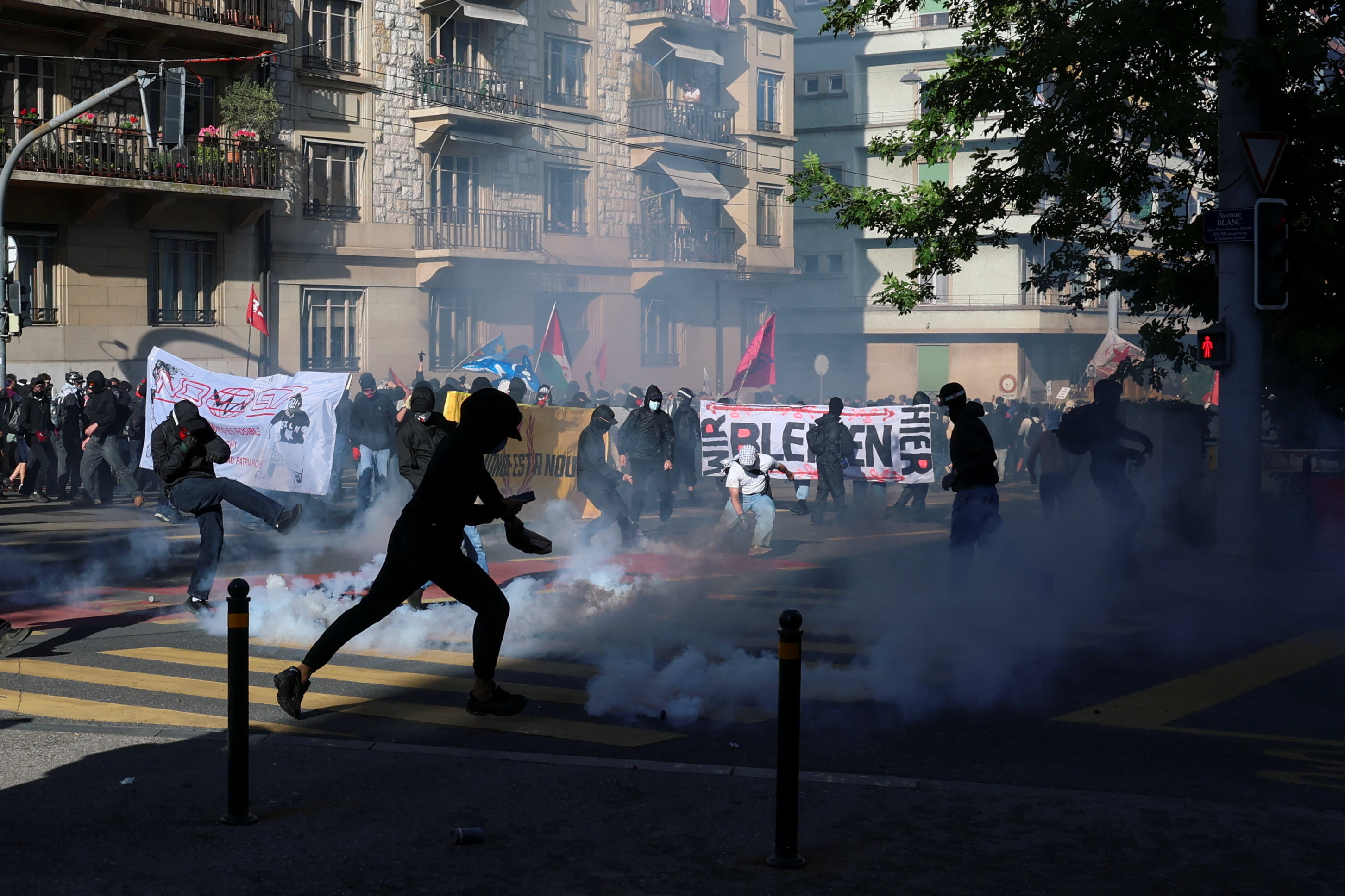 People react amid tear gas during clashes with riot police officers amid a protest against the upcoming G7 summit in Evian-les-Bains in France, in Geneva, Switzerland, June 14, 2026. REUTERS/Denis Balibouse