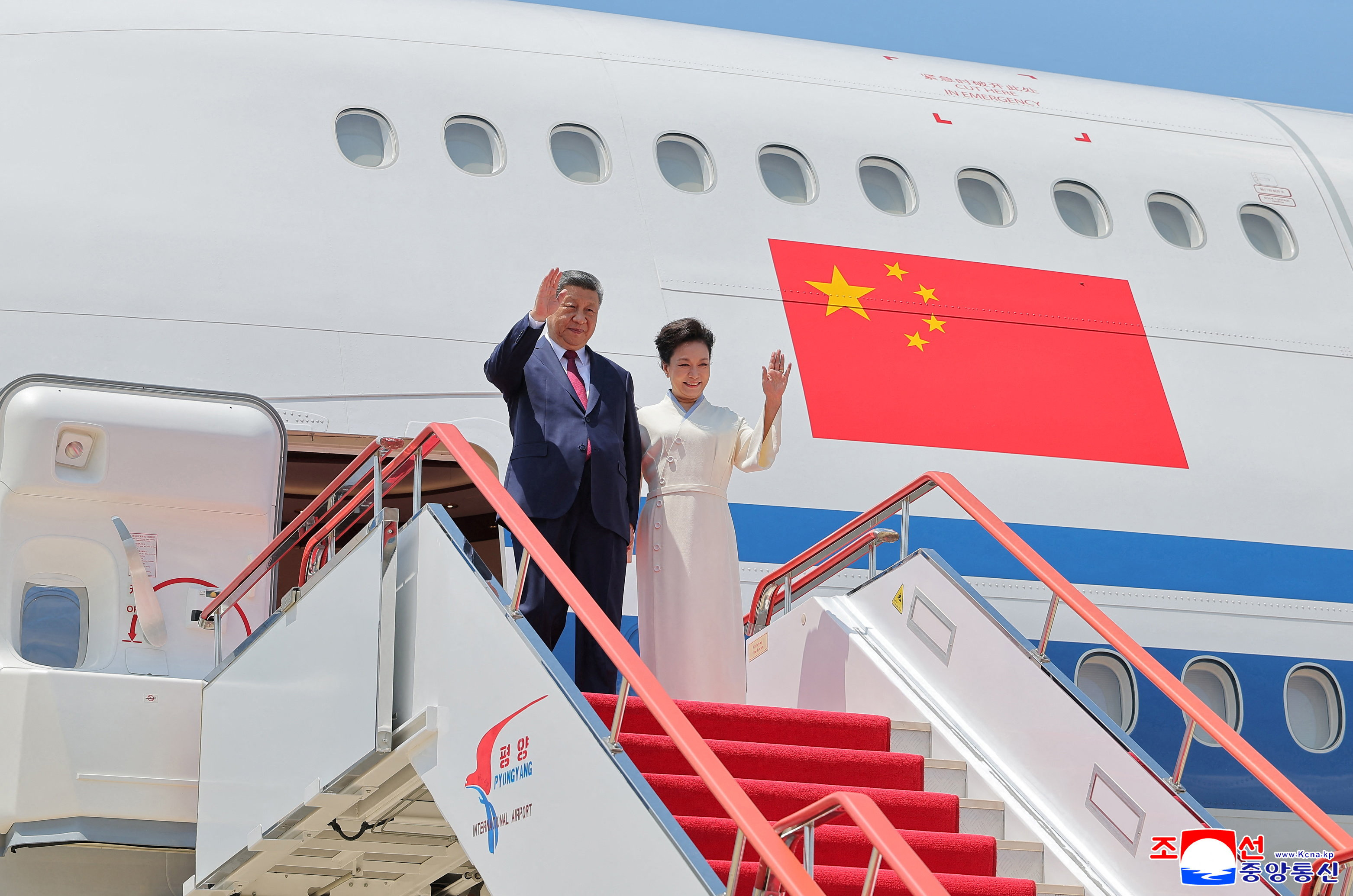 Chinese President Xi Jinping and his wife first lady Peng Liyuan disembark at Pyongyang Airport during Xi's state visit to Pyongyang, North Korea