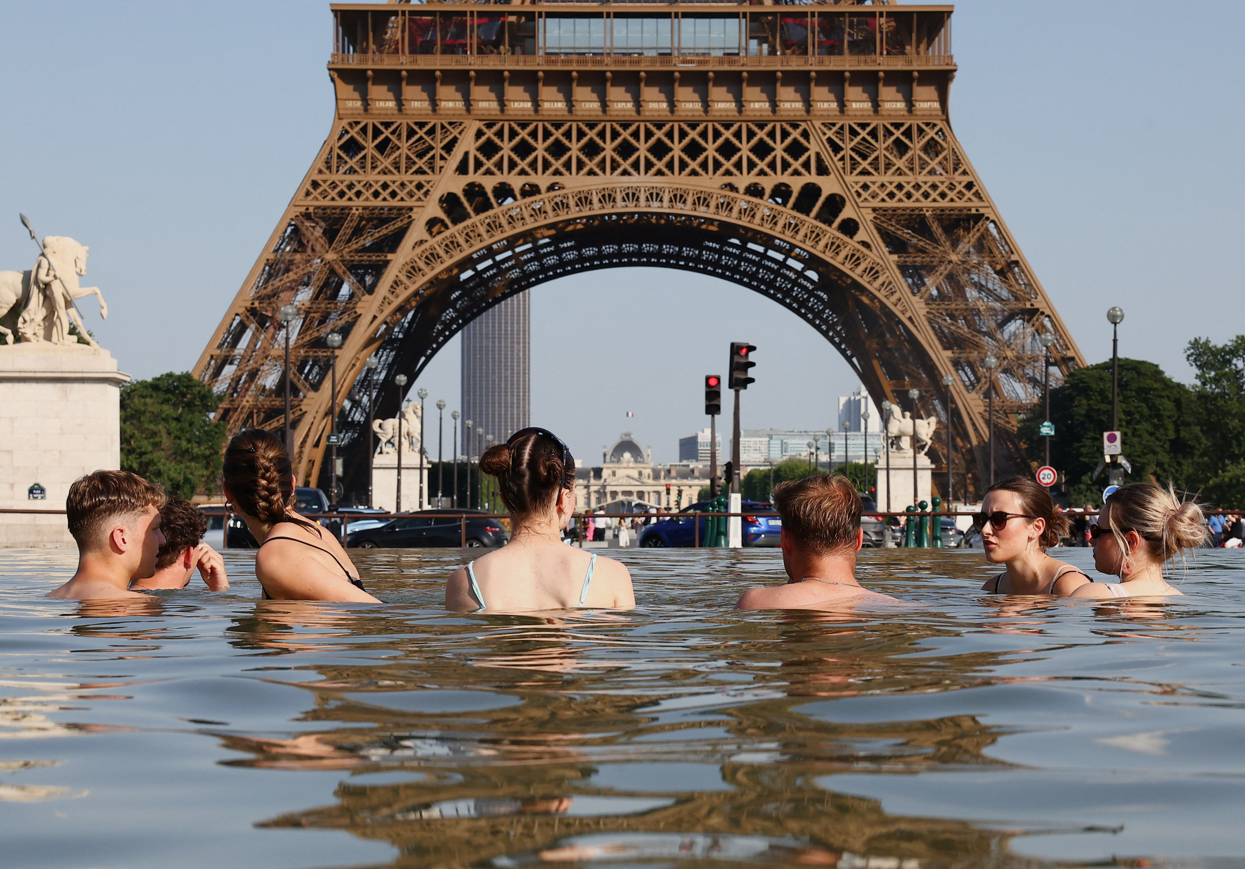 People cool off in the Trocadero Fountain next to the Eiffel Tower as temperatures rise during a heatwave affecting a large part of the country, in Paris, France, June 22, 2026. REUTERS/Abdul Saboor