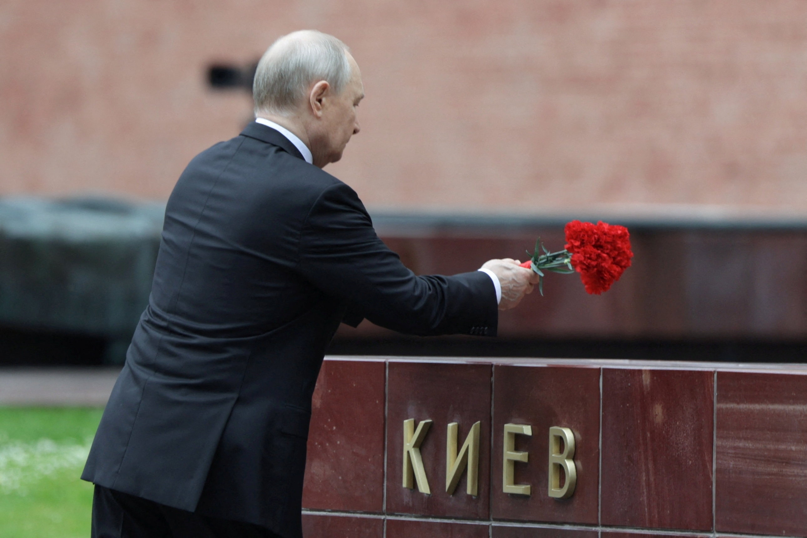 Russian President Vladimir Putin lays flowers at the Hero Cities memorial plates by the Kremlin wall during a ceremony on the Remembrance and Sorrow Day, marking the 85th anniversary of the Nazi German invasion into the Soviet Union in World War II