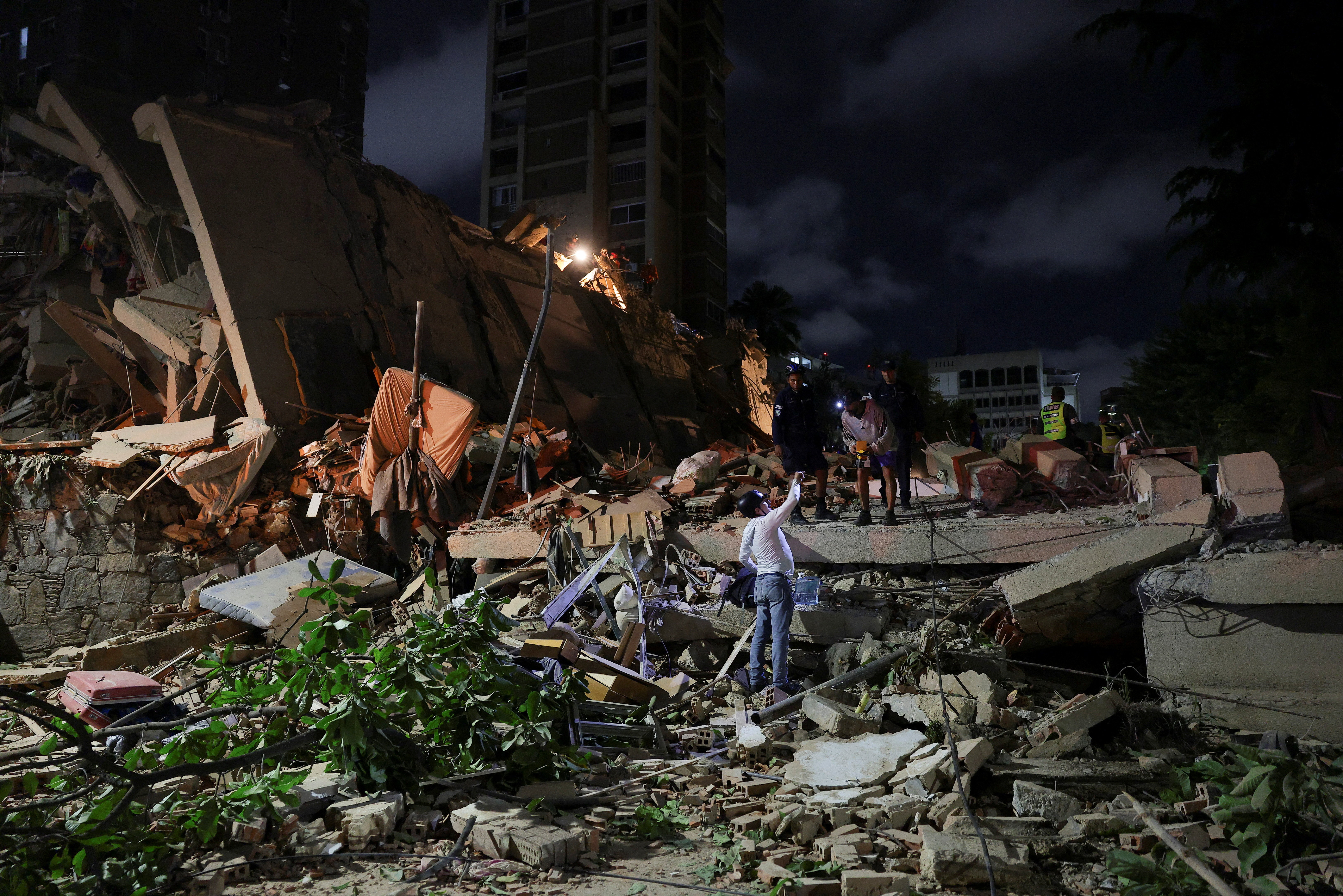 Emergency services work at the site of a collapsed building after an earthquake, in Caracas, Venezuela, June 24, 2026. REUTERS/Gaby Oraa     TPX IMAGES OF THE DAY