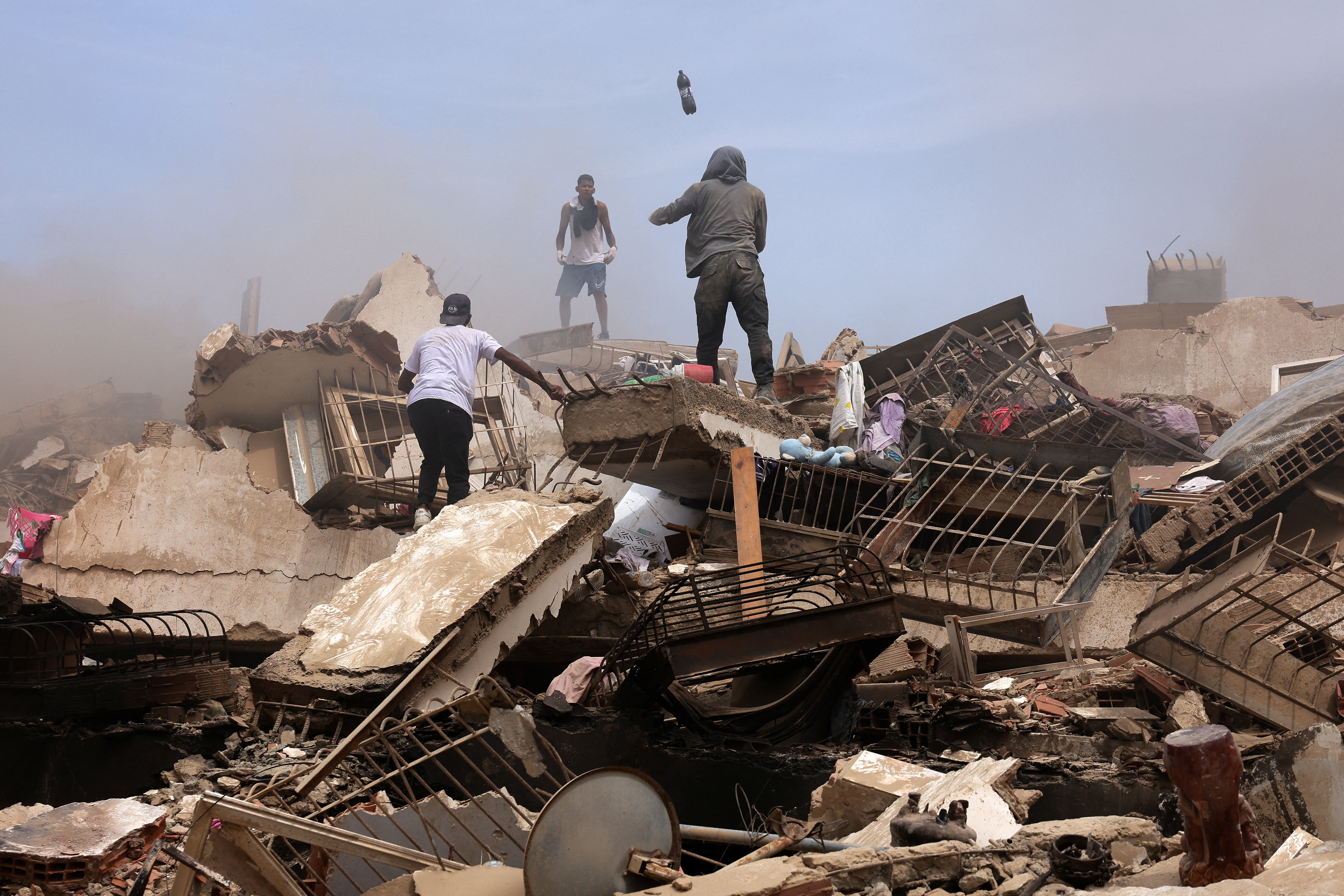 People search for casualties amid the rubble of collapsed buildings, in the aftermath of earthquakes in La Guaira, Venezuela, June 25, 2026.