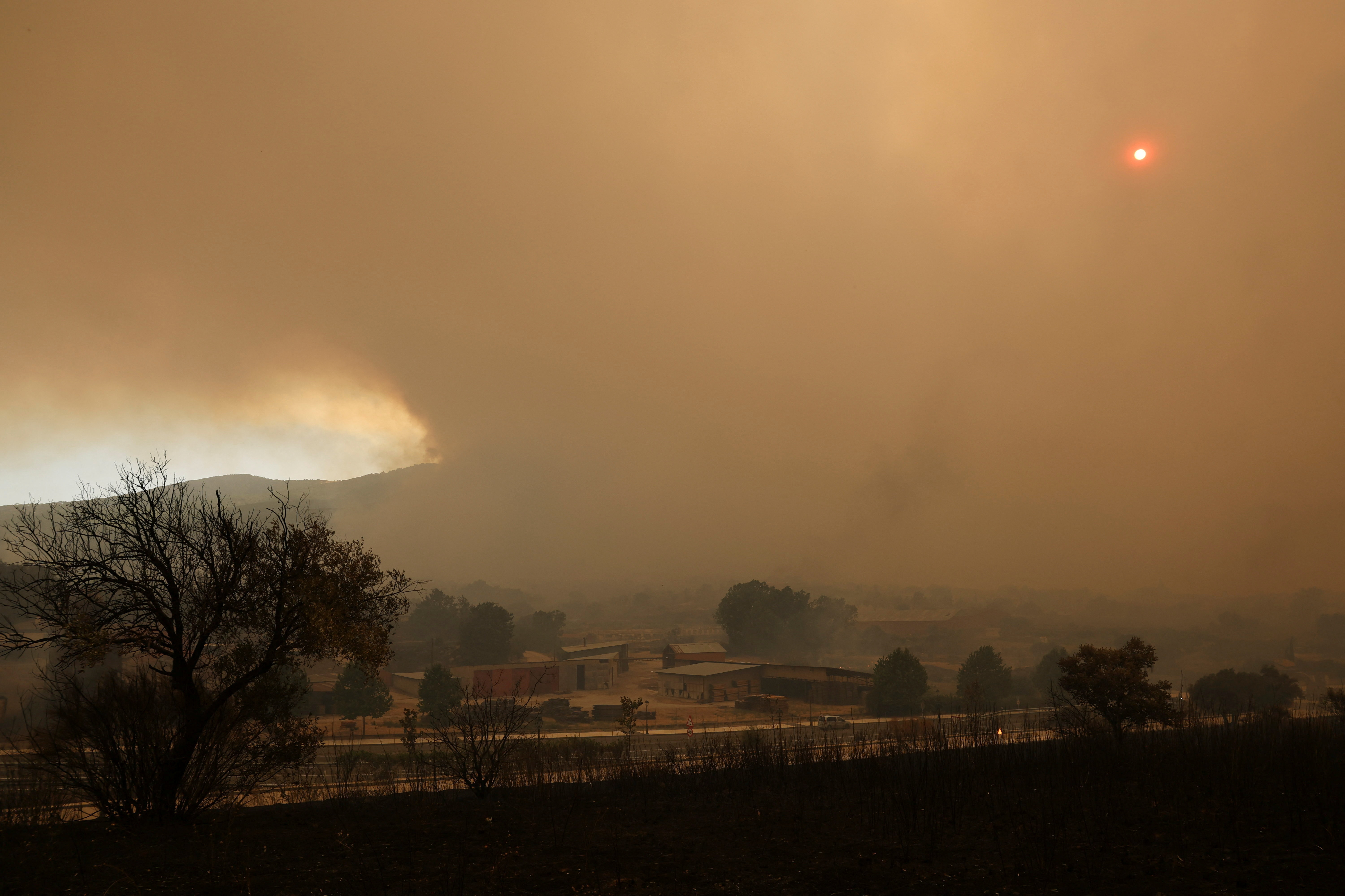 Smoke from wildfires affecting Castile y Leon province obscures the sun in the village of El Tiemblo, Spain, July 24, 2026.