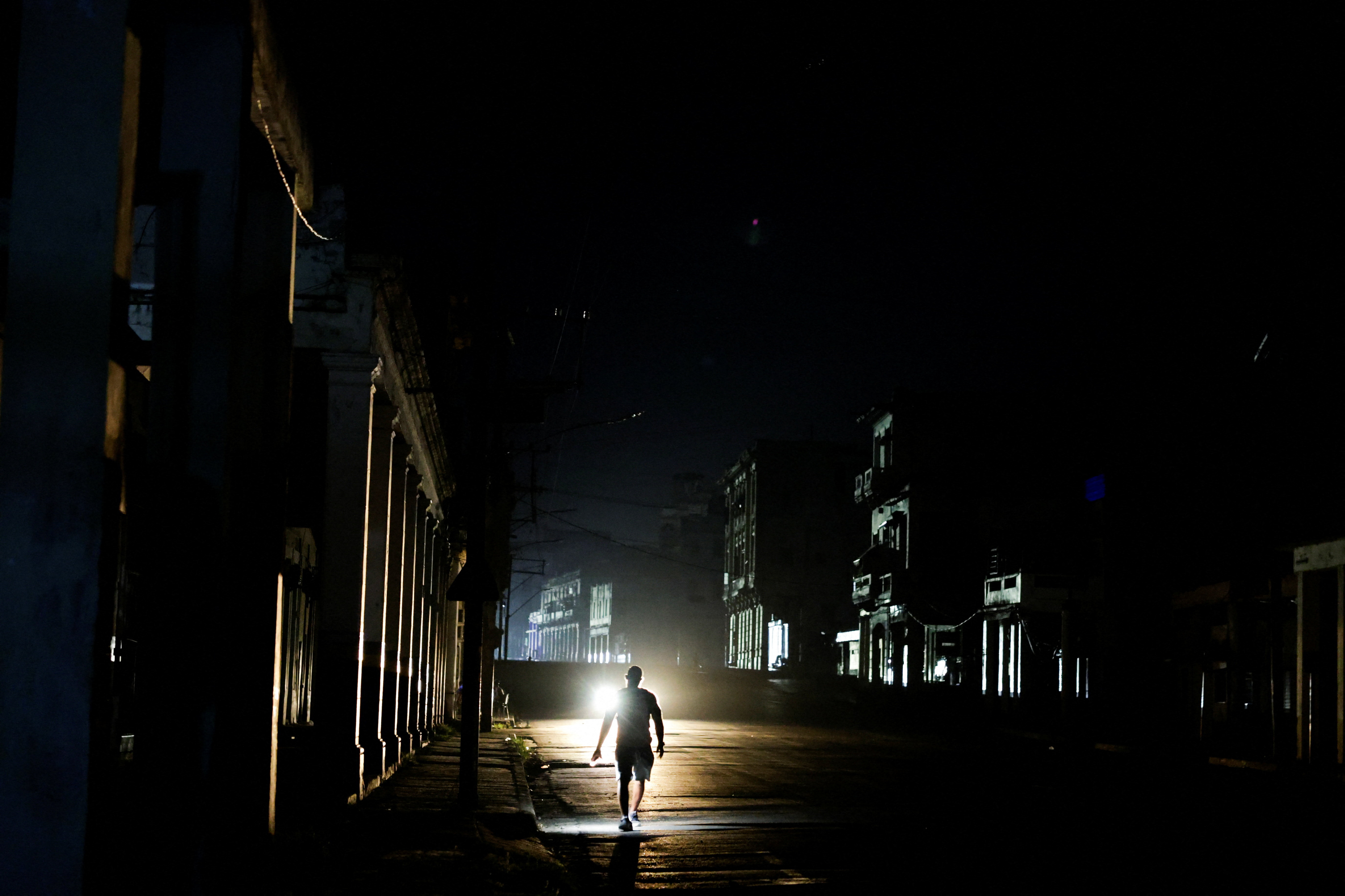 A man walks down a dark street as Cuba's electricity grid collapsed late on Sunday, plunging the island of about 10 million people into darkness as blackouts become more frequent, in Havana, Cuba August 3, 2026. REUTERS/Norlys Perez