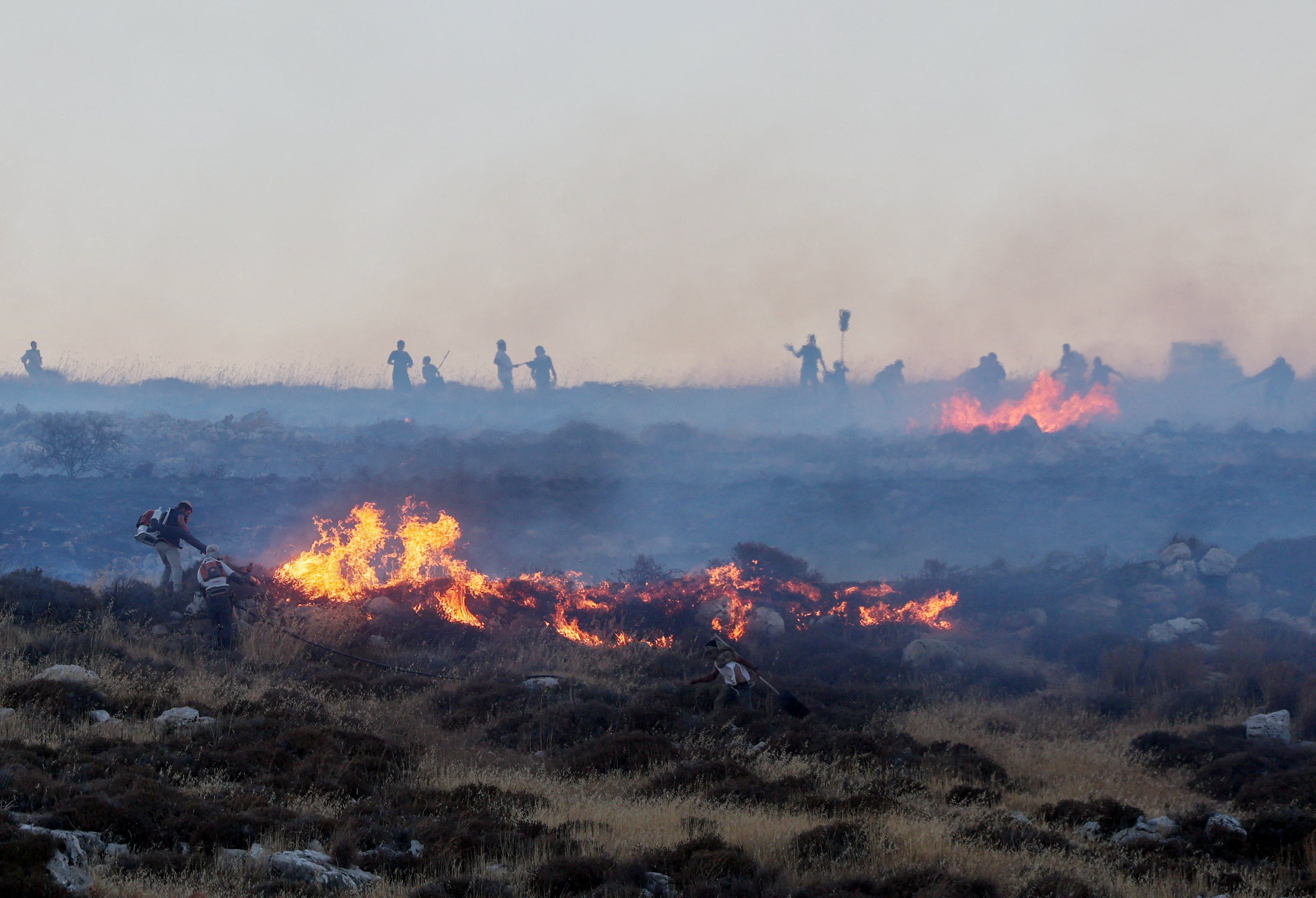 FILE PHOTO: Israeli settlers put out a fire by a settler outpost, near the Palestinian town Taybeh in the Israeli-occupied West Bank, July 17, 2026.