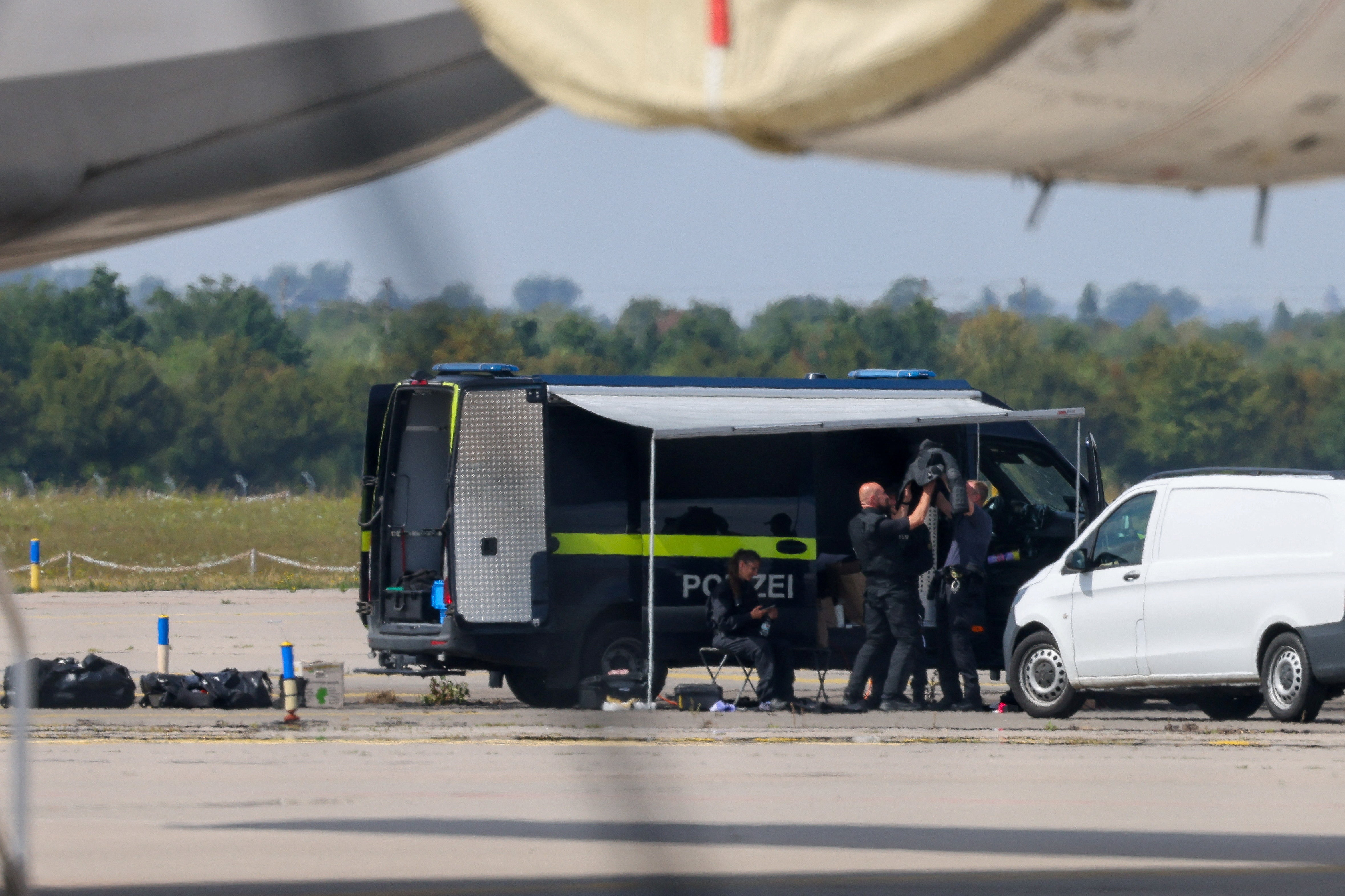 Police officers work in the vicinity of an Antonov cargo plane,. REUTERS/Axel Schmidt