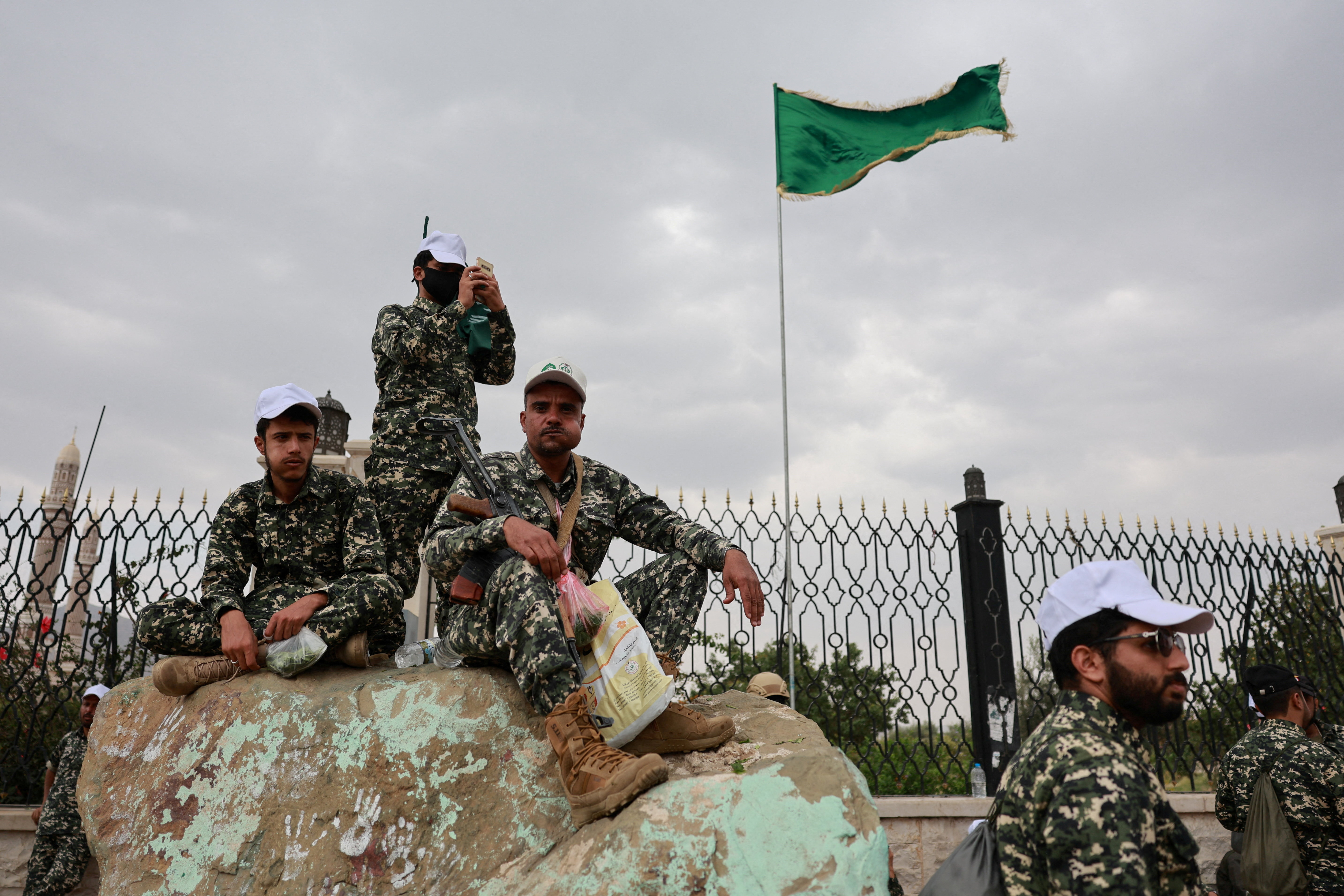 Members of Houthi security forces sit on a rock at the site of a rally held to commemorate Mawlid, marking the anniversary of Prophet Muhammad's birthday
