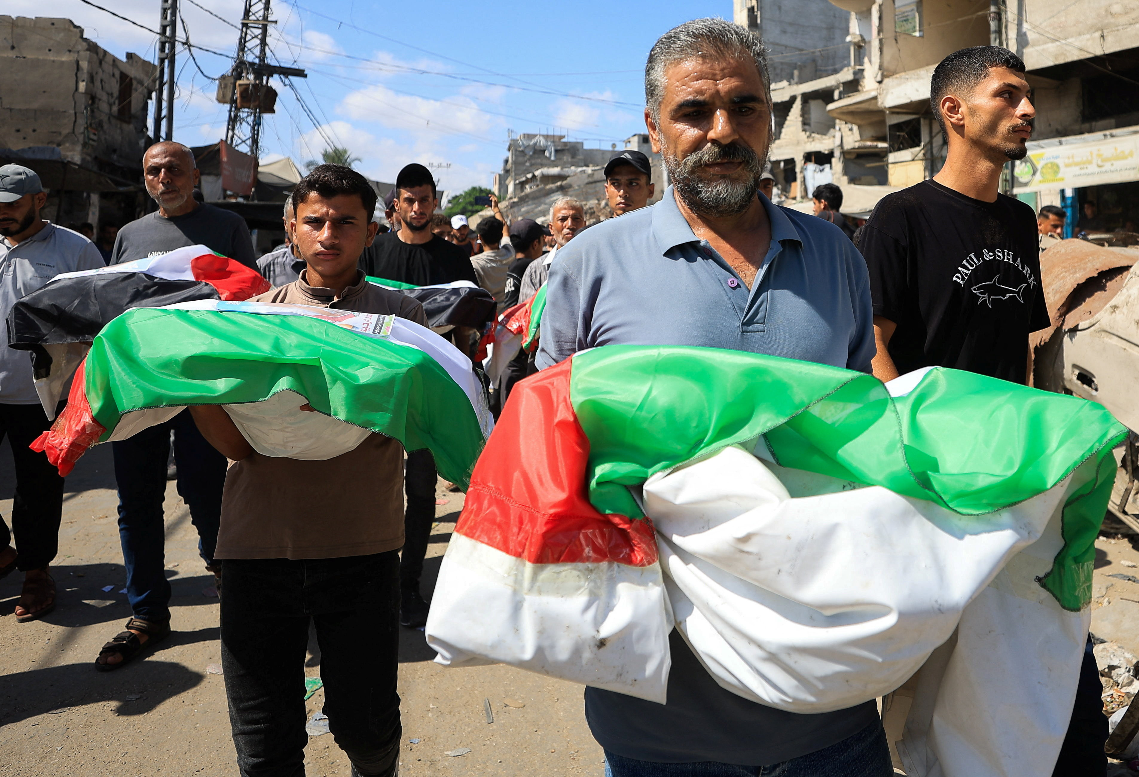 Mourners carry bodies covered in Palestinian flags, on the day of the mass funeral for members of the Irahem, Malaka, Qanbour, Balawi and Dahdouh families, who were killed in an Israeli strike in 2023