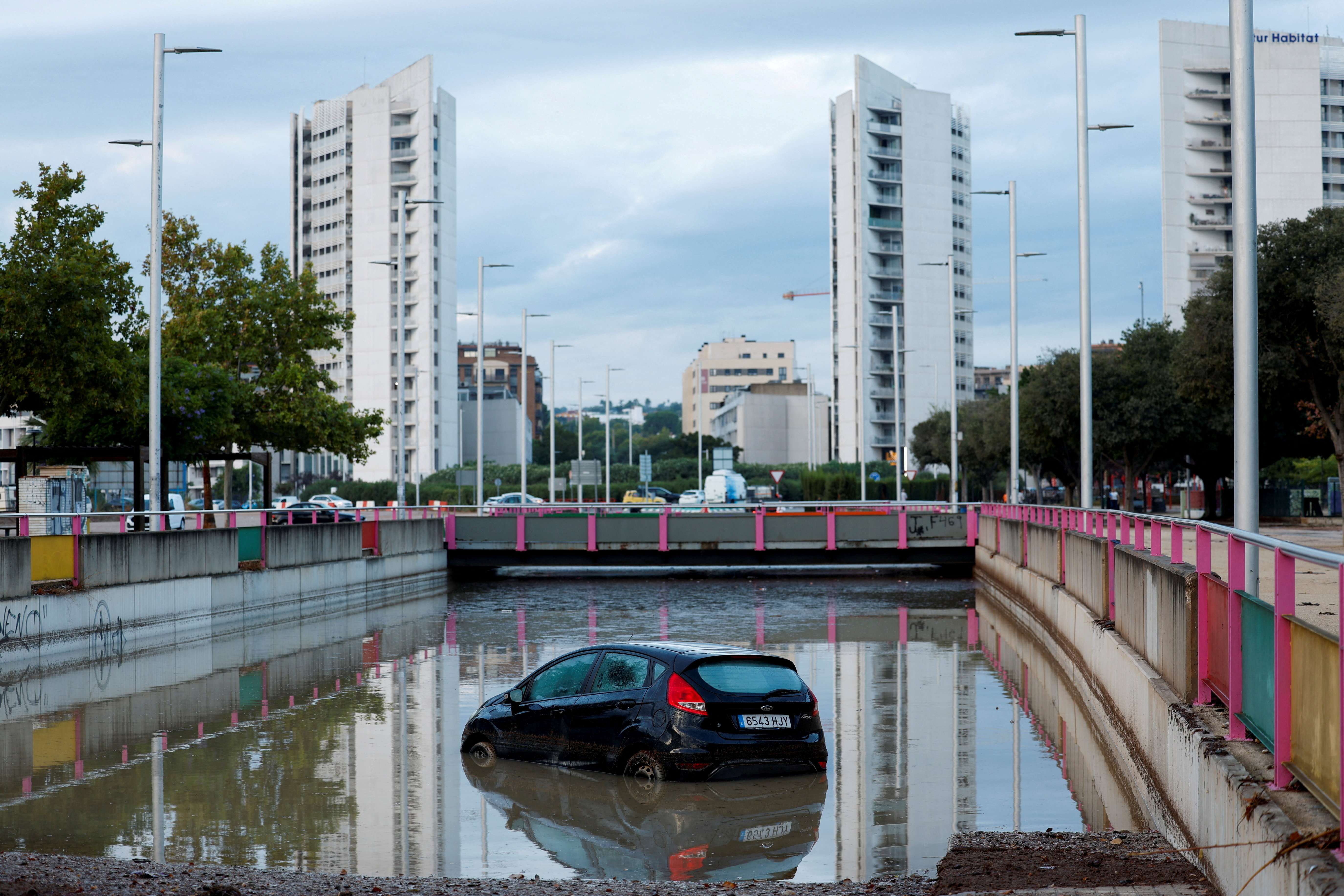 A car partially submerged at the entrance of a flooded underpass.  REUTERS/Eva Manez