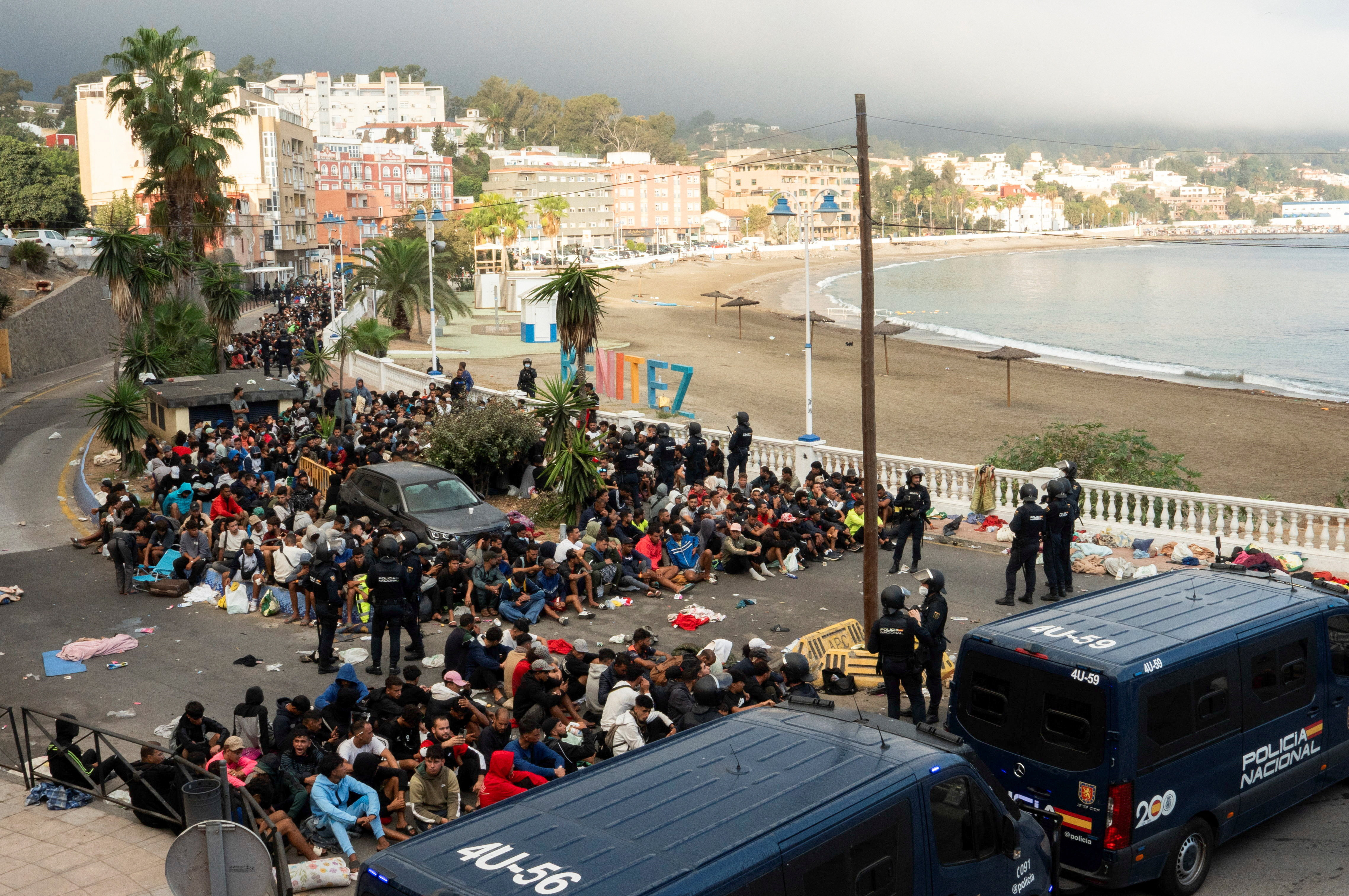 Police escort migrants from Benitez Beach to be relocated to the camp set up at the port of Ceuta, Spain, September 18, 2026. REUTERS/ Anna Surinyach