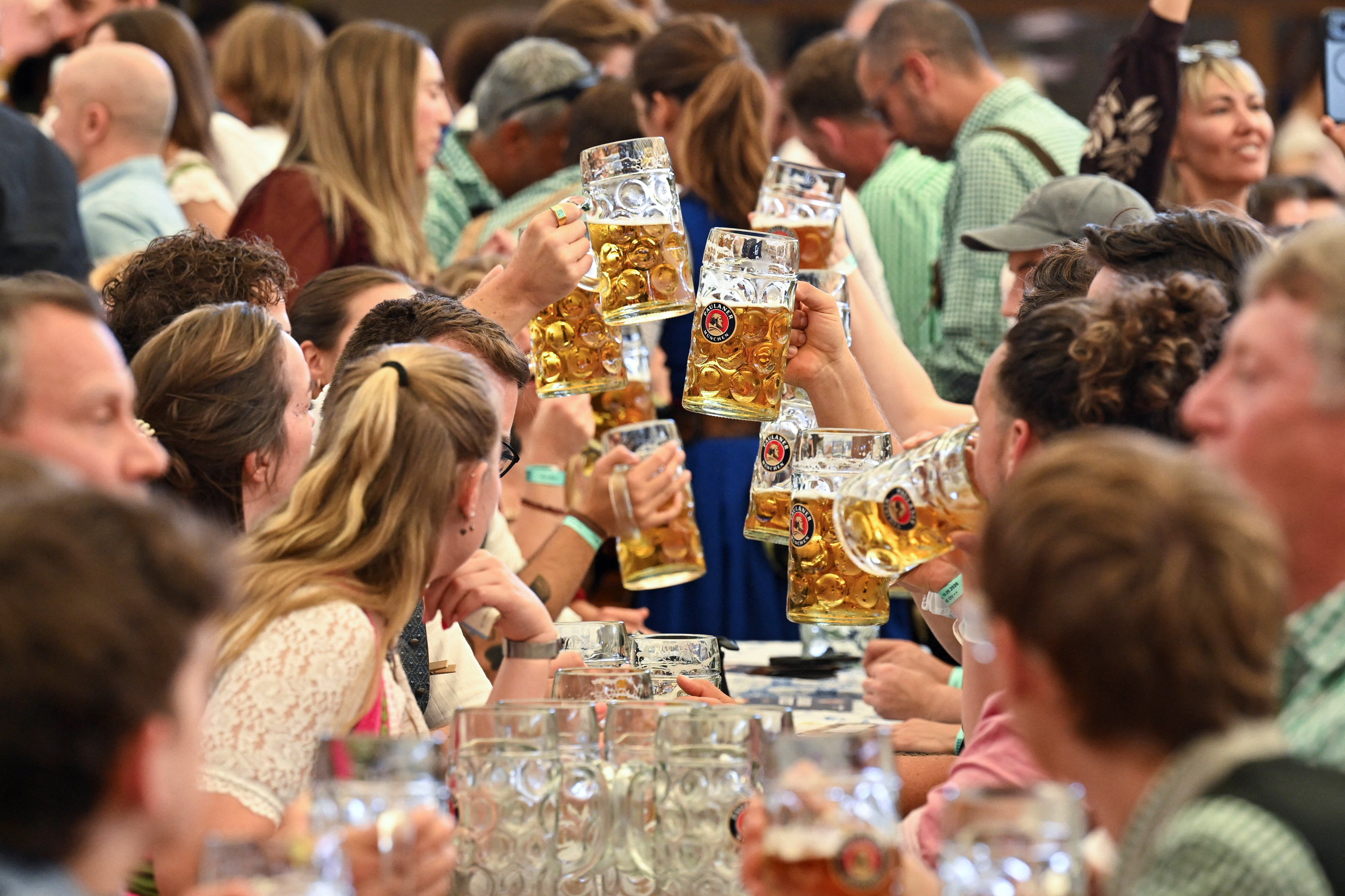 People hold mugs of beer during the official opening day of the 191st Oktoberfest, the world's largest beer festival in Munich, Germany, September 19, 2026. REUTERS/Angelika Warmuth