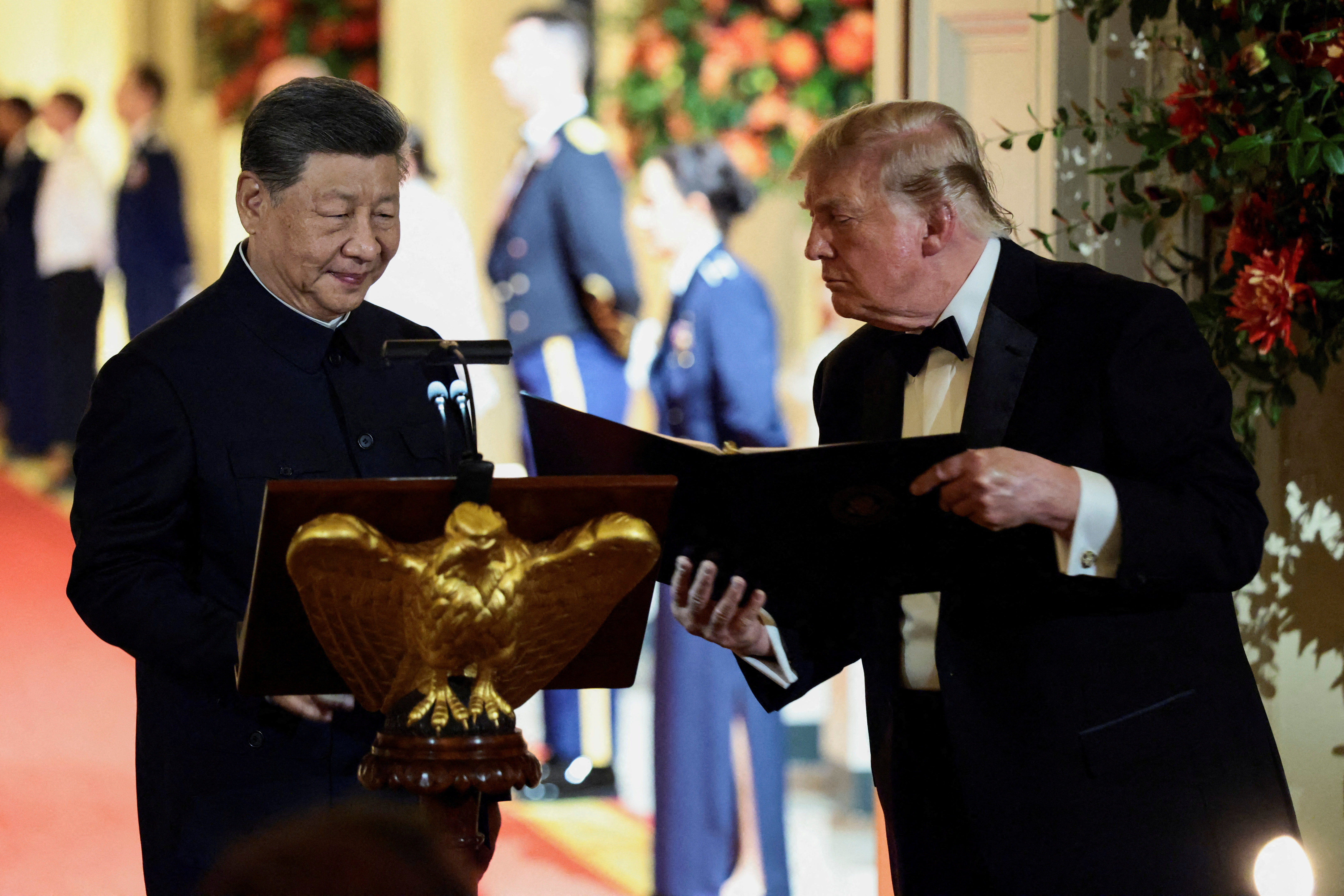 US President Donald Trump holds a binder as he stands next to Chinese President Xi Jinping before Xi delivers a speech during a state dinner at the White House in Washington, D.C., US, September 24, 2026.