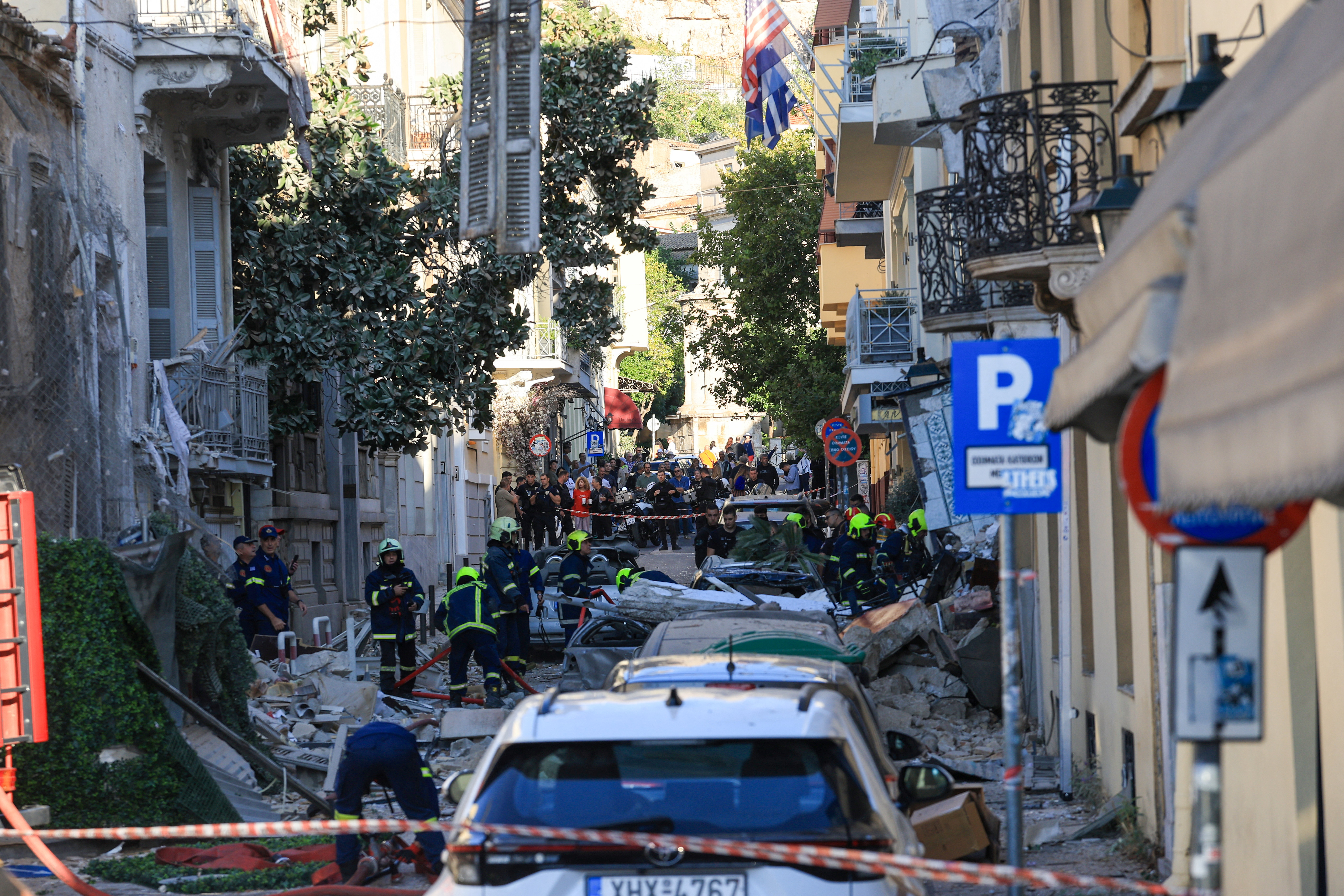 Emergency personnel work at the site where an old building partially collapsed. REUTERS/Louisa Gouliamaki