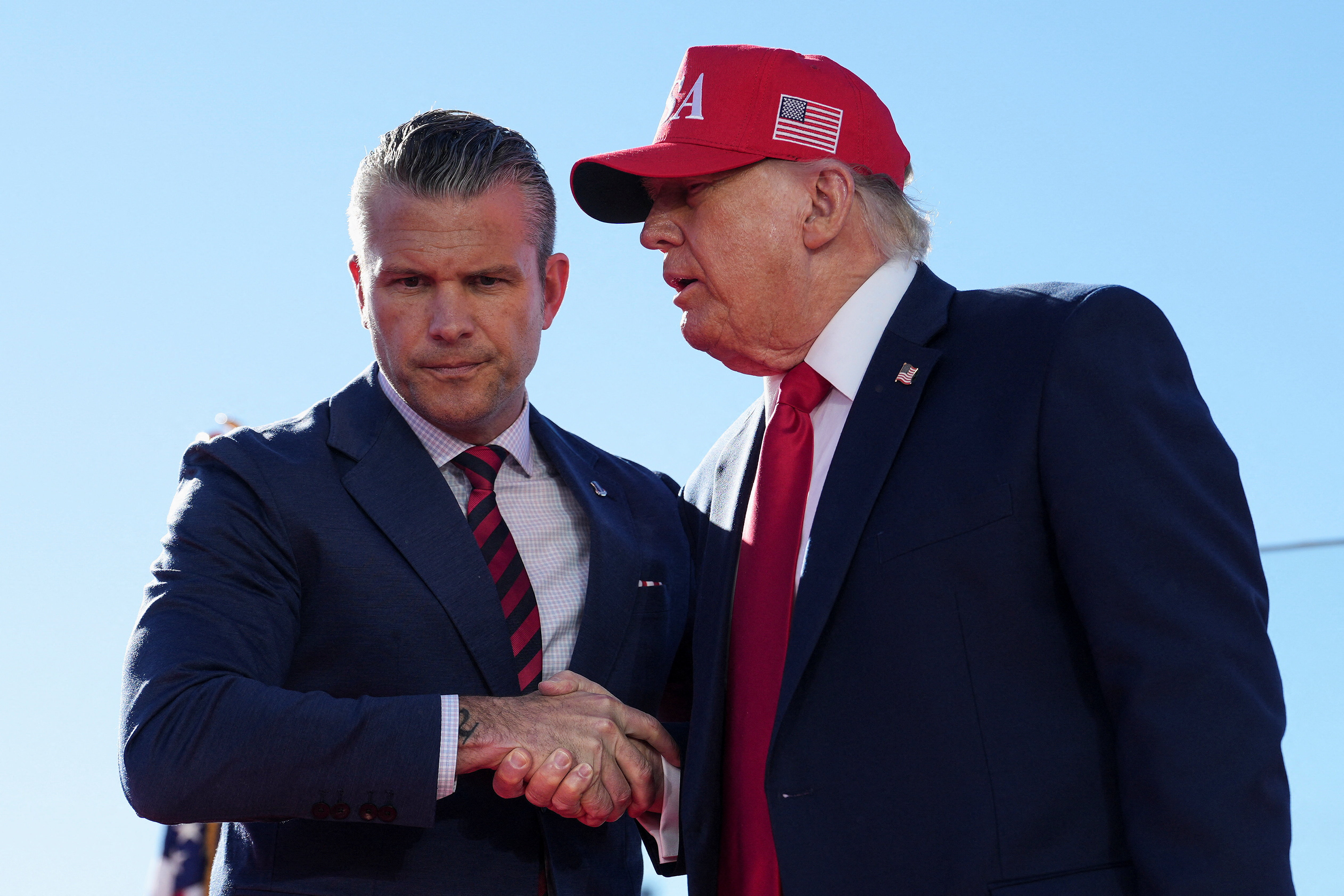 US Defense Secretary Pete Hegseth shakes hands with US President Donald Trump onstage during an event at Sparrows Point Shipyard, in Baltimore County, Maryland, US, October 6, 2026.