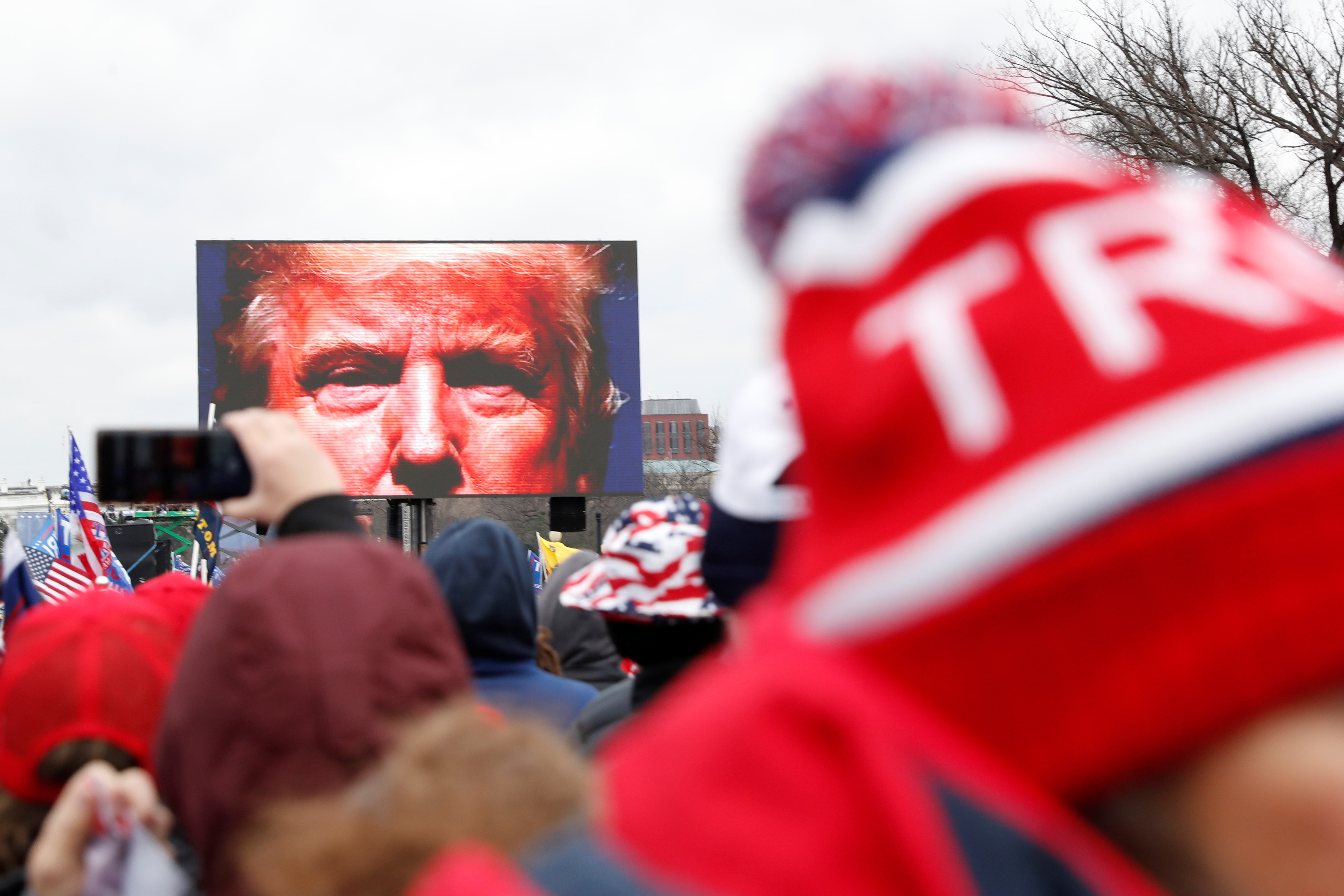 U.S. President Donald Trump is seen on a screen speaking to supporters during a rally to contest the certification of the 2020 U.S. presidential election results by the U.S. Congress, in Washington