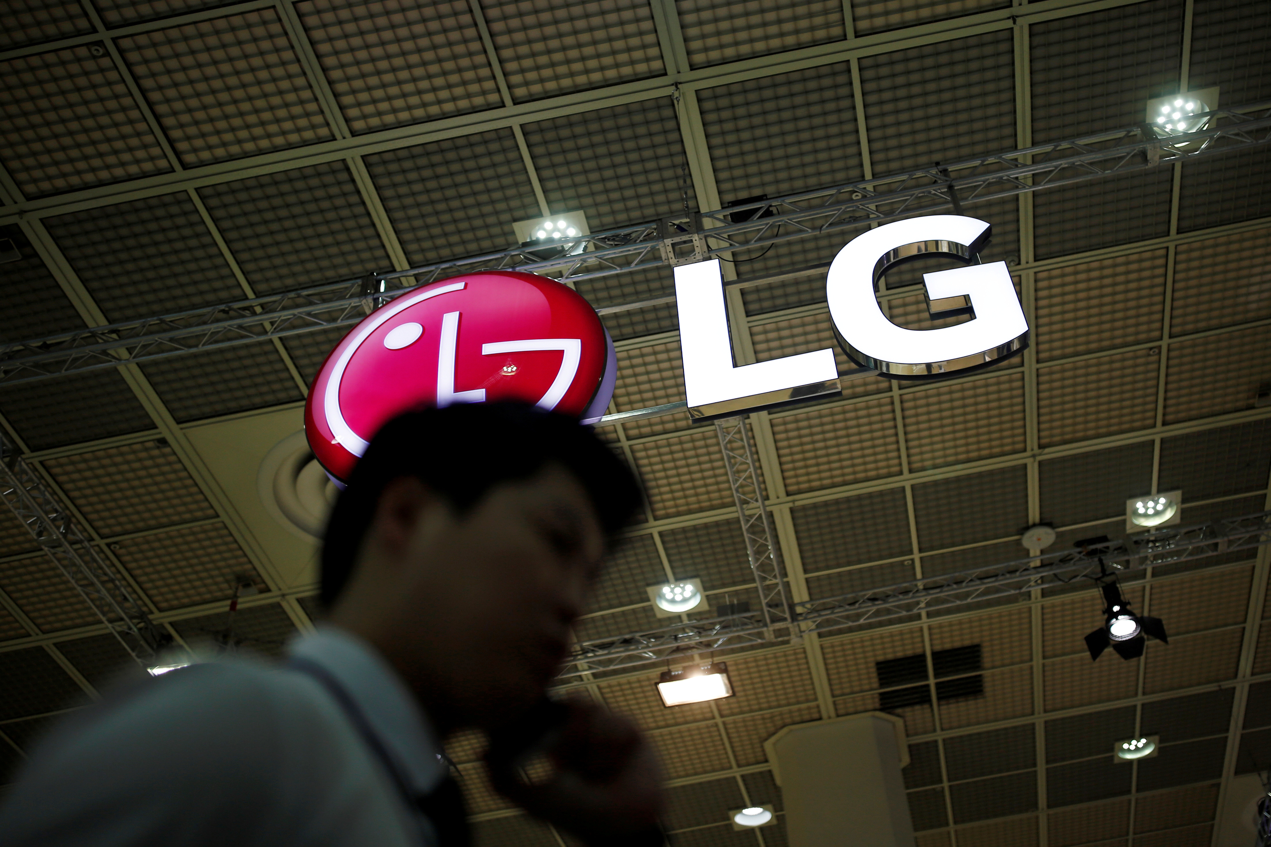 LG, tehnologija FILE PHOTO: A man talking on his phone walks past the logo of LG Electronics during Korea Electronics Show 2016 in Seoul