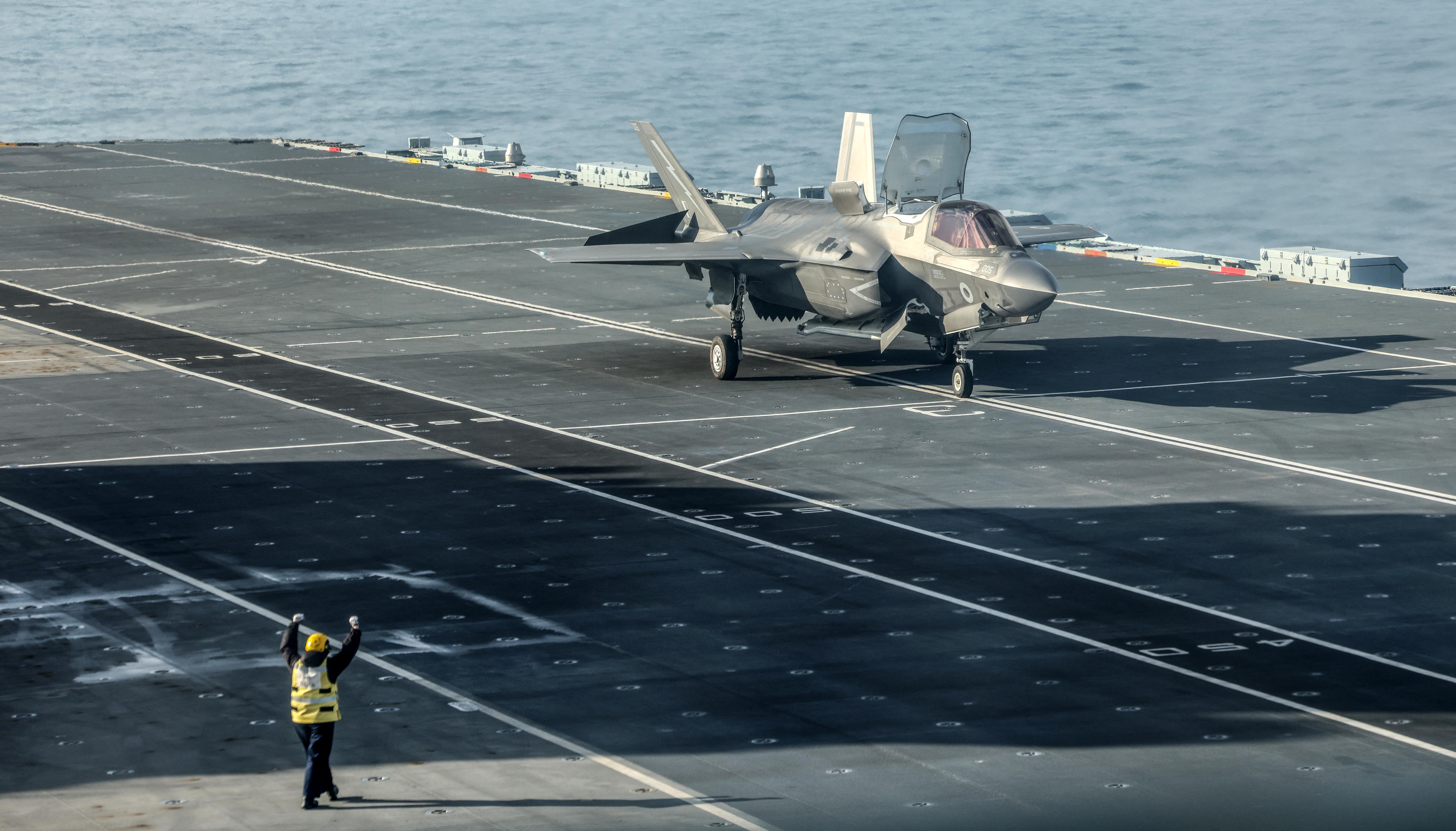 A Royal Navy F-35B Lightning fighter jet lands on the deck of British aircraft carrier HMS Prince Of Wales, in an undisclosed location, on April 24, 2025, following its deployment to the Indo-Pacific region. (Photo by RICHARD POHLE / POOL / AFP)