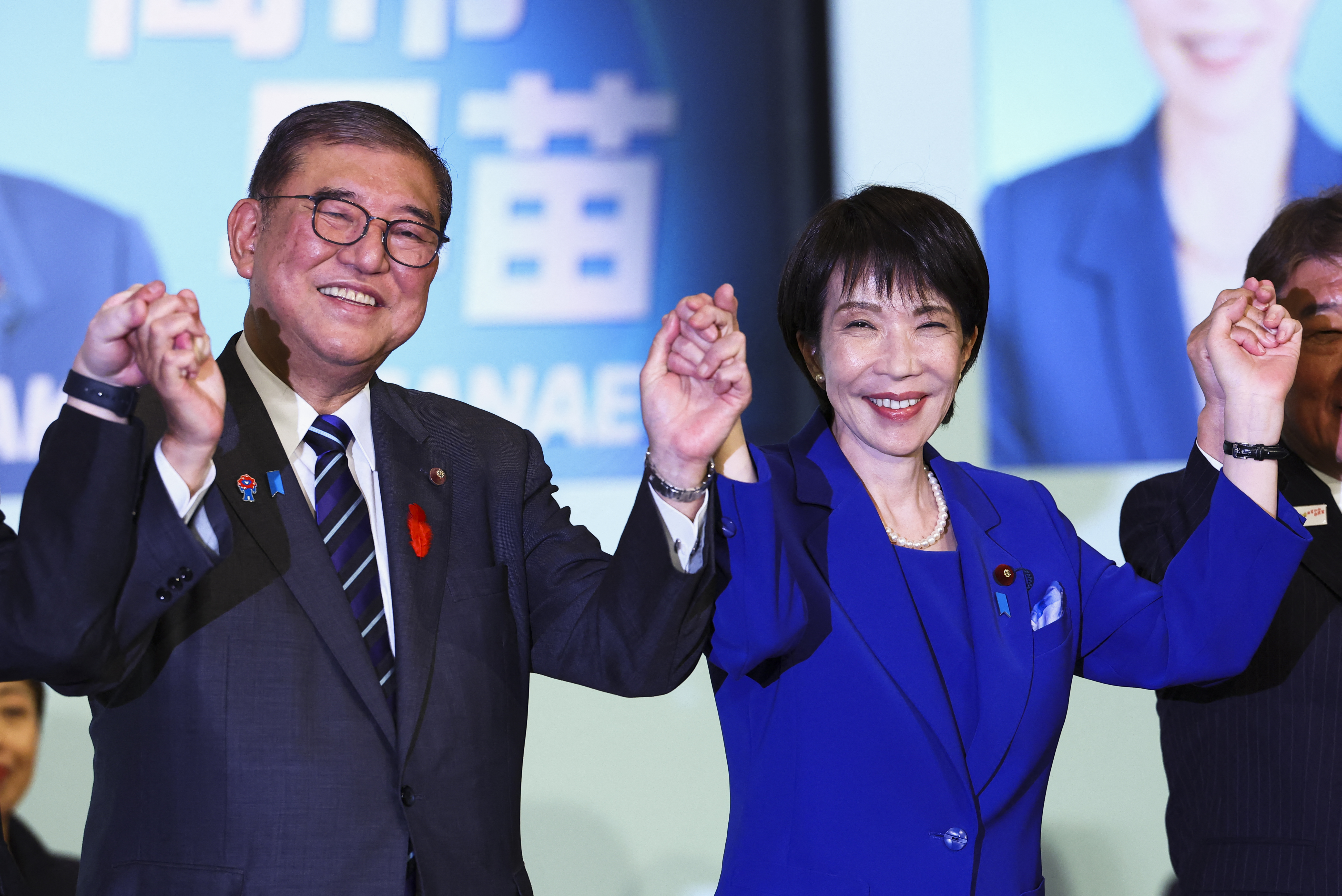 (FILES) Newly-elected leader of Japan's Liberal Democratic Party (LDP) Sanae Takaichi (R) celebrates with Prime Minister Shigeru Ishiba after winning the LDP leadership election in Tokyo
