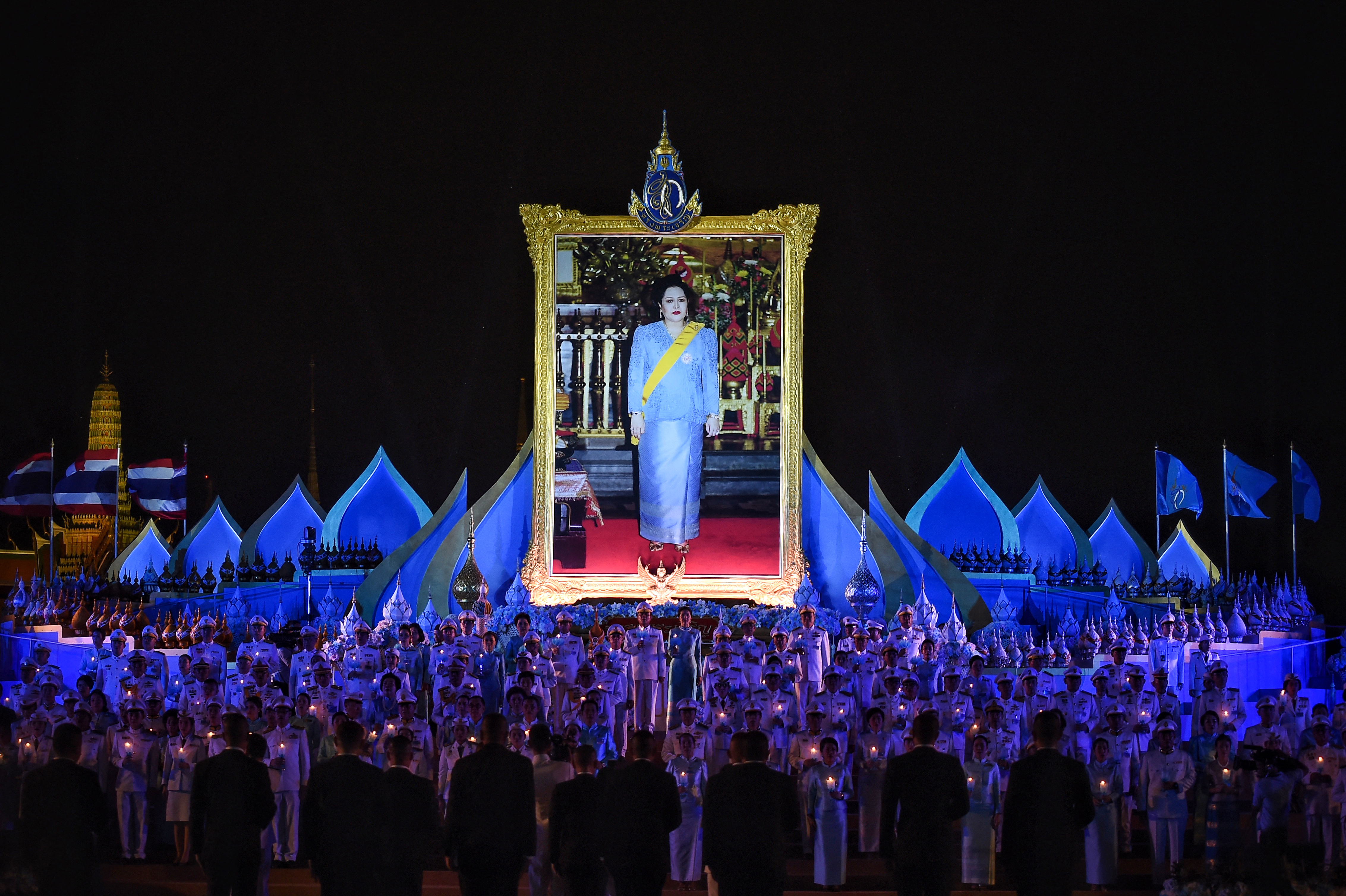 Thailand's Prime Minister Prayut Chan-O-Cha and wife Naraporn Chan-O-Cha (C) light candles with Thai officials during Queen Mother Sirikit's 87th birthday celebrations in Bangkok on August 12, 2019. (Photo by Lillian SUWANRUMPHA / AFP)