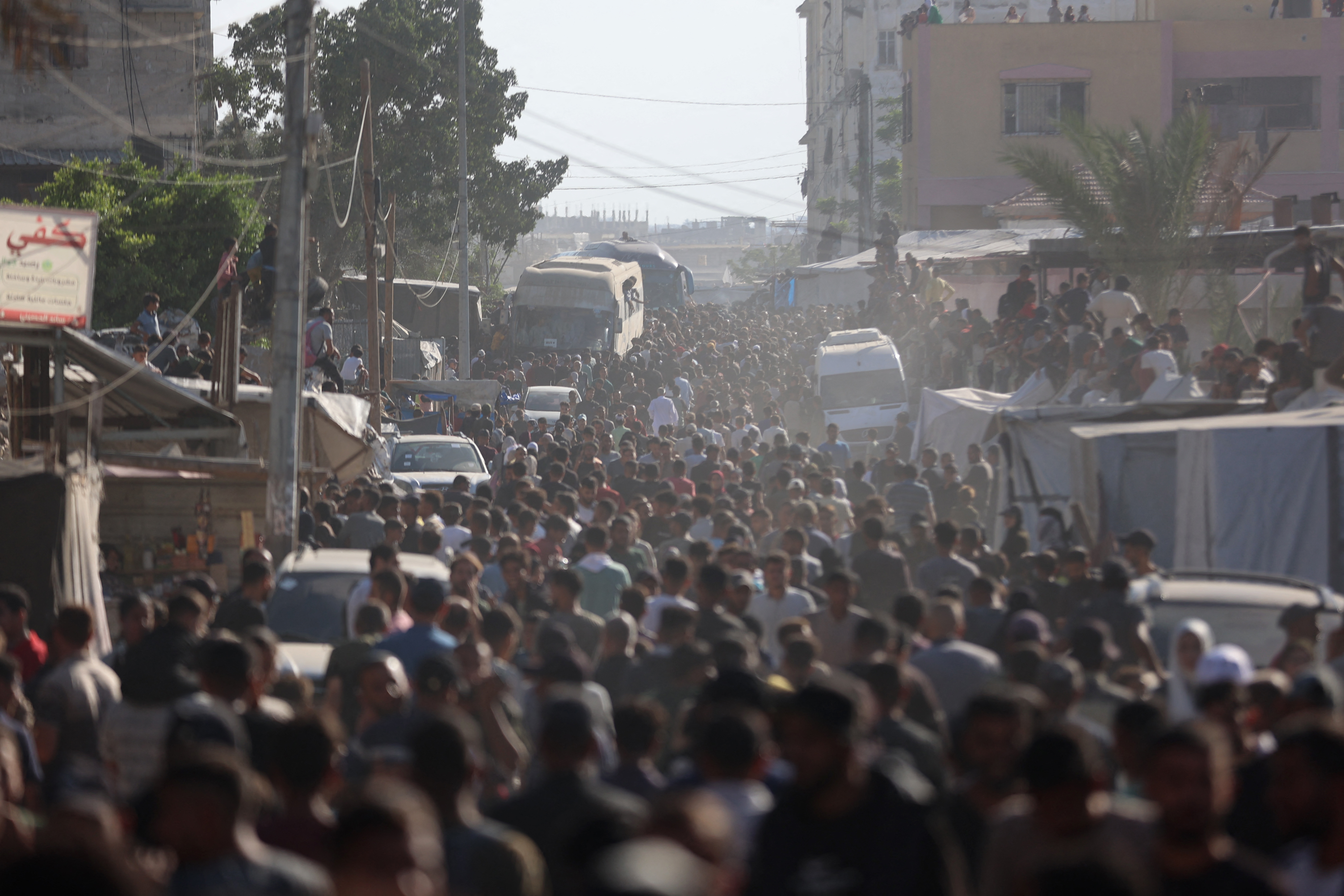 People gather to welcome Palestinians released from Israeli prisons under a Gaza ceasefire and hostage exchange deal with Palestinian factions, as the buses carrying them arrives outside the Nasser hospital in Khan Yunis