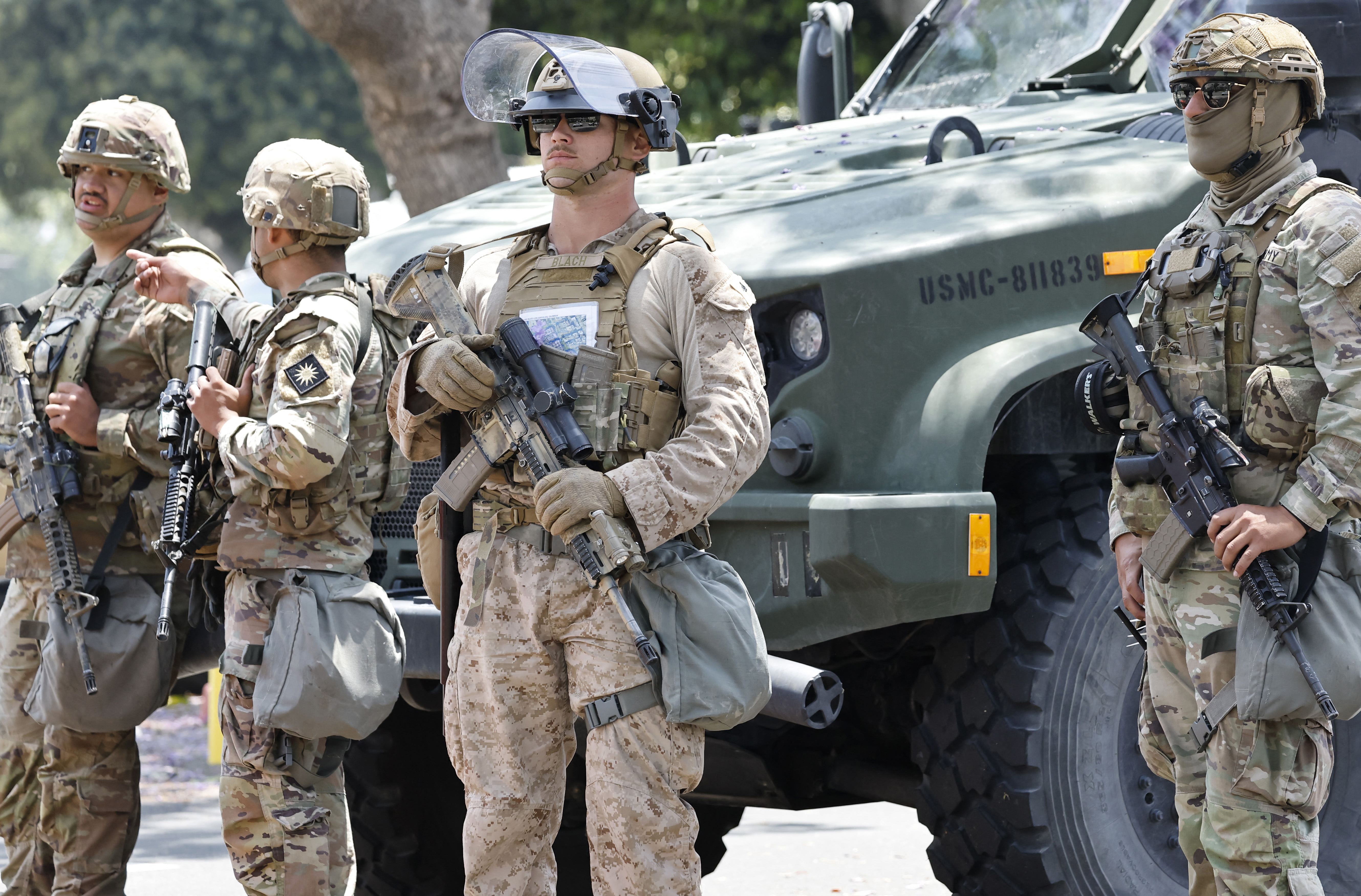 U.S. Marine (C) and California National Guard soldiers guard an entrance to the Wilshire Federal Building, while standing by a U.S. Marine tactical vehicle