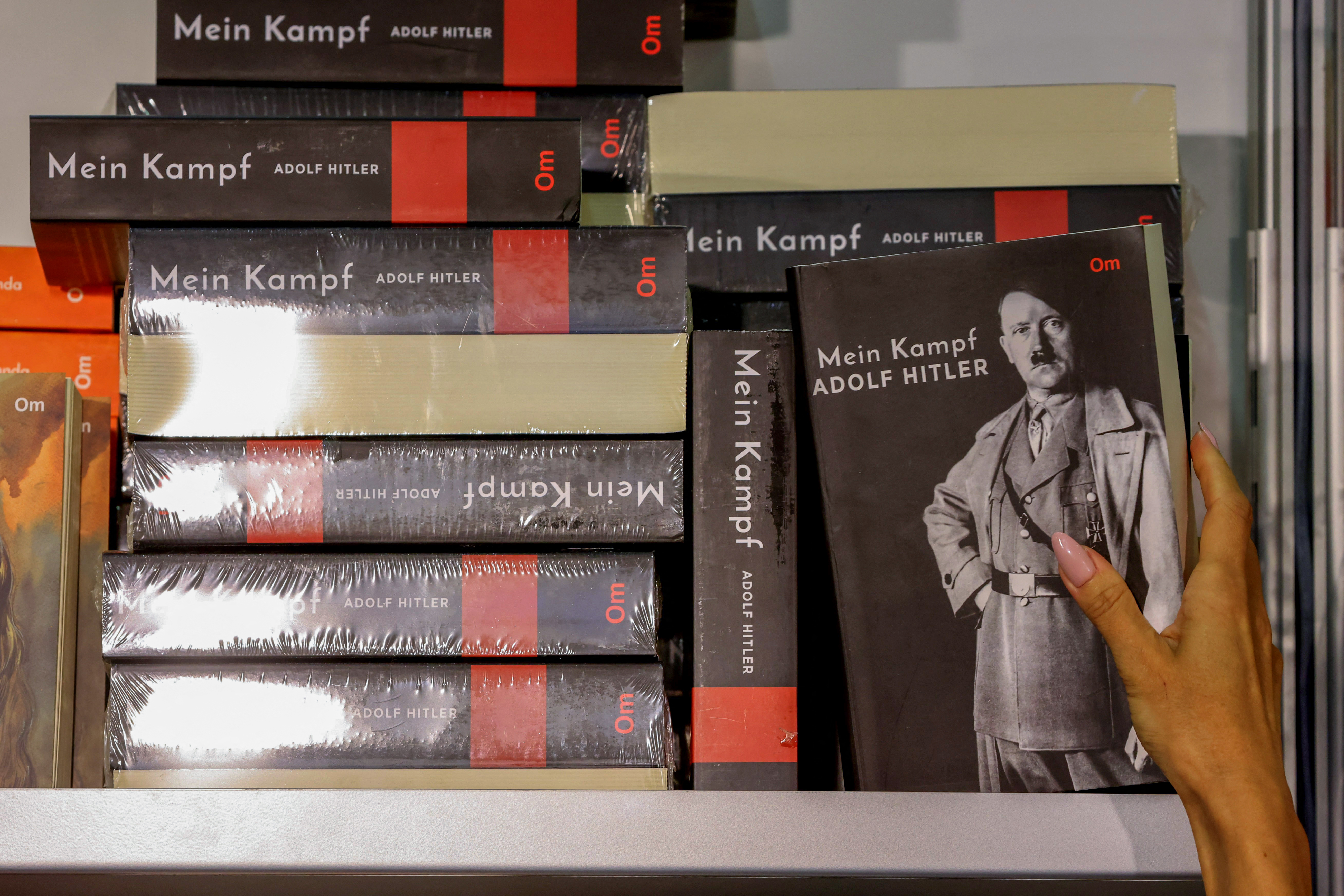 A woman reaches for a copy of Adolf Hitler's book "Mein Kampf" at the Sharjah International Book Fair
