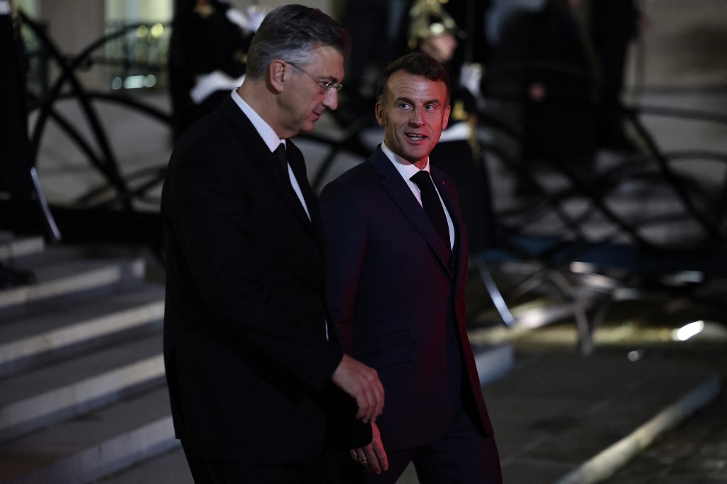 France's President Emmanuel Macron (R) walks with Croatia's Prime Minister Andrej Plenkovic as he leaves after a meeting at the Elysee Palace in Paris, on December 8, 2025. (Photo by Anne-Christine POUJOULAT / AFP)