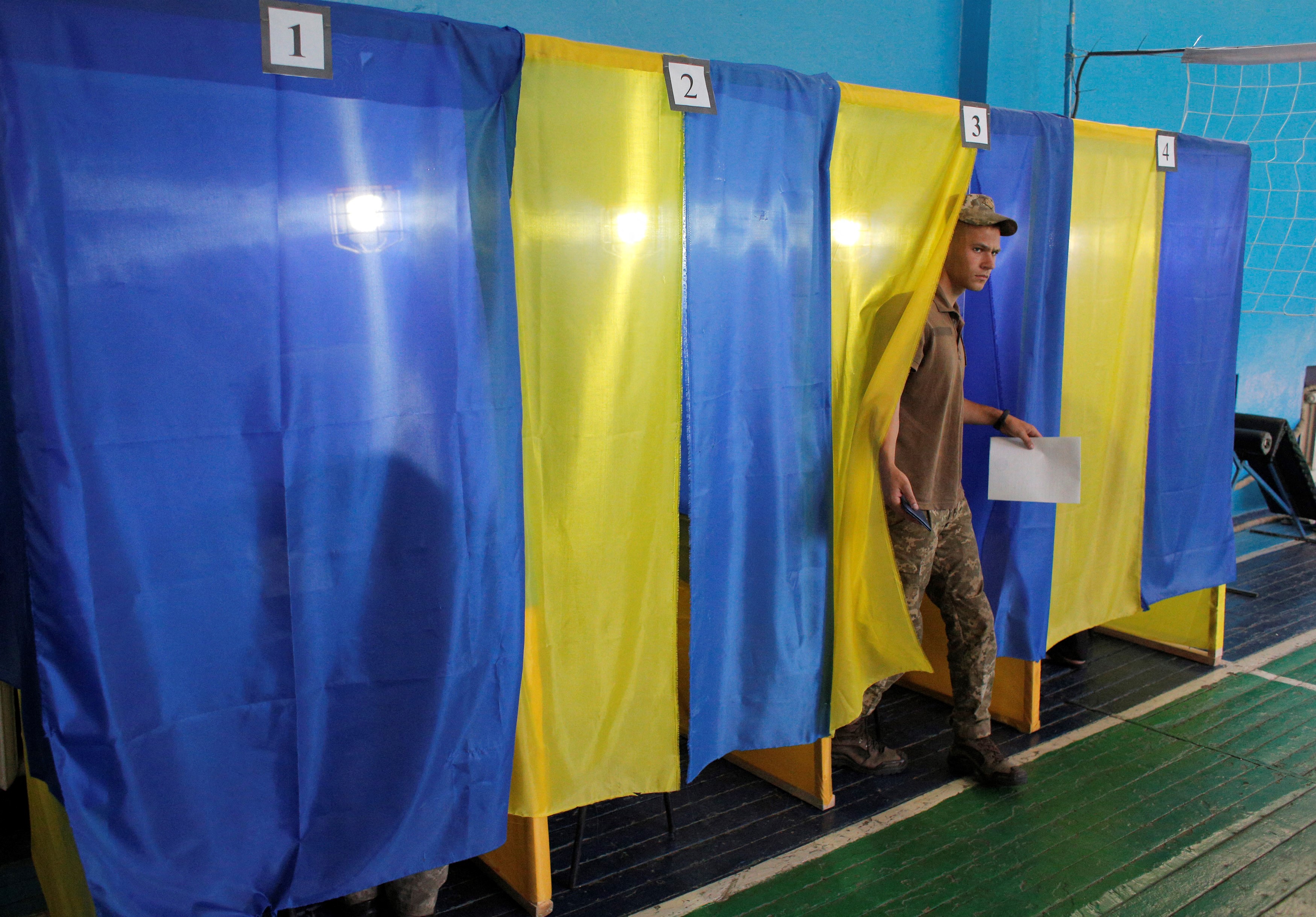 An Ukrainian serviceman walks out of a voting booth at a polling station in the town of Avdiivka.