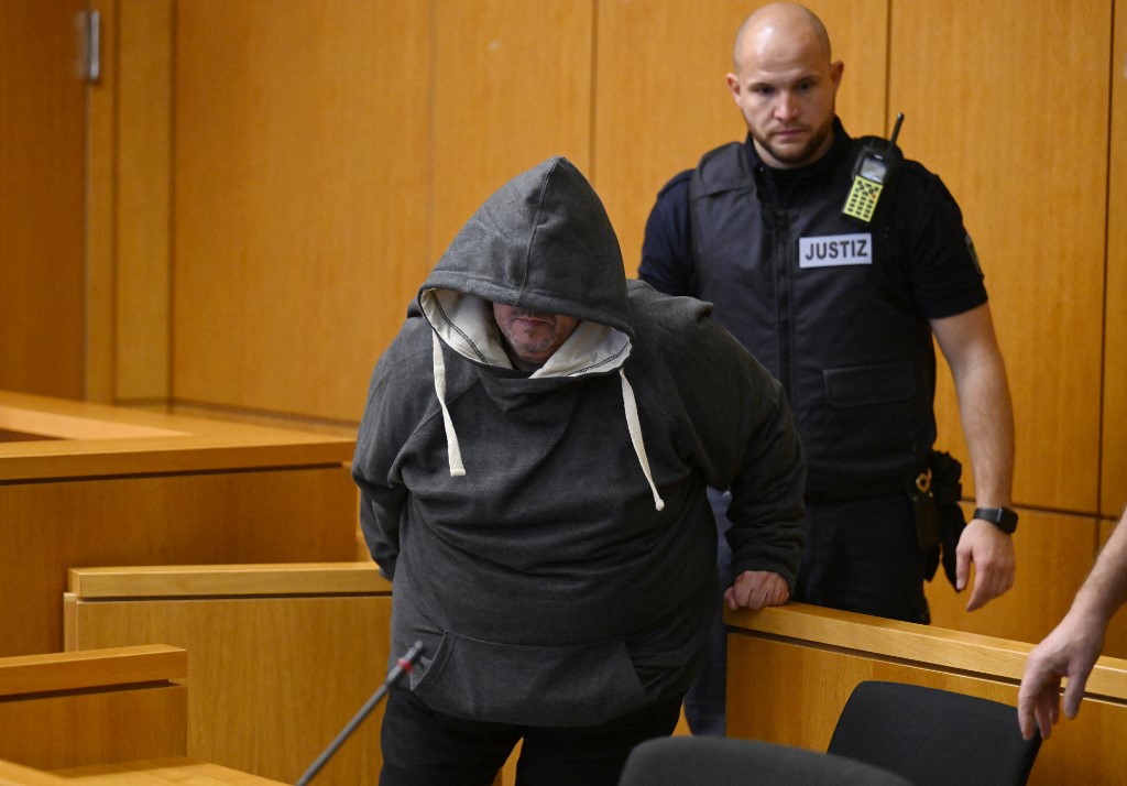The defendant Fernando P. is escorted by a justice officer at the regional court to hear the verdict in the case where he is accused of drugging and raping his wife in Aachen, western Germany, December 19, 2025. (Photo by Roberto Pfeil / AFP)