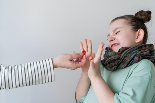 A little girl refuses to take the pill. Selected focus. High quality photo