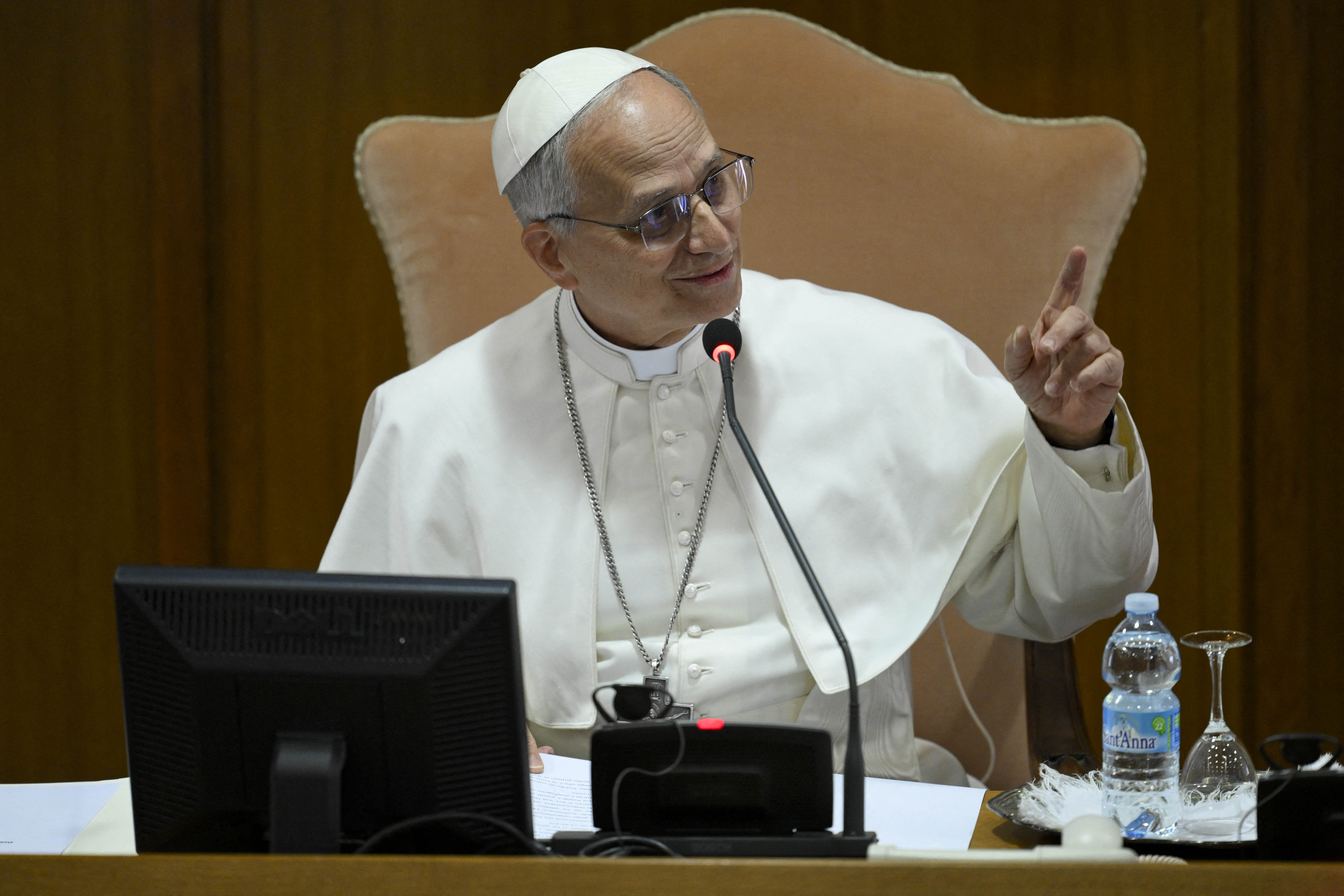 Papa Lav XIV. sjedi za stolom i priča u mikrofon