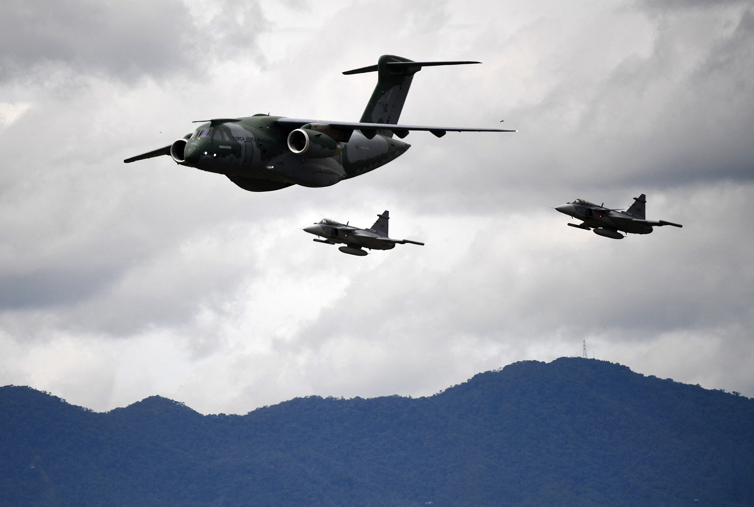 A Brazilian Air Force pilot with his Embraer C-390 Millennium aircraft, escorted by two Saab JAS 39 Gripen fighters