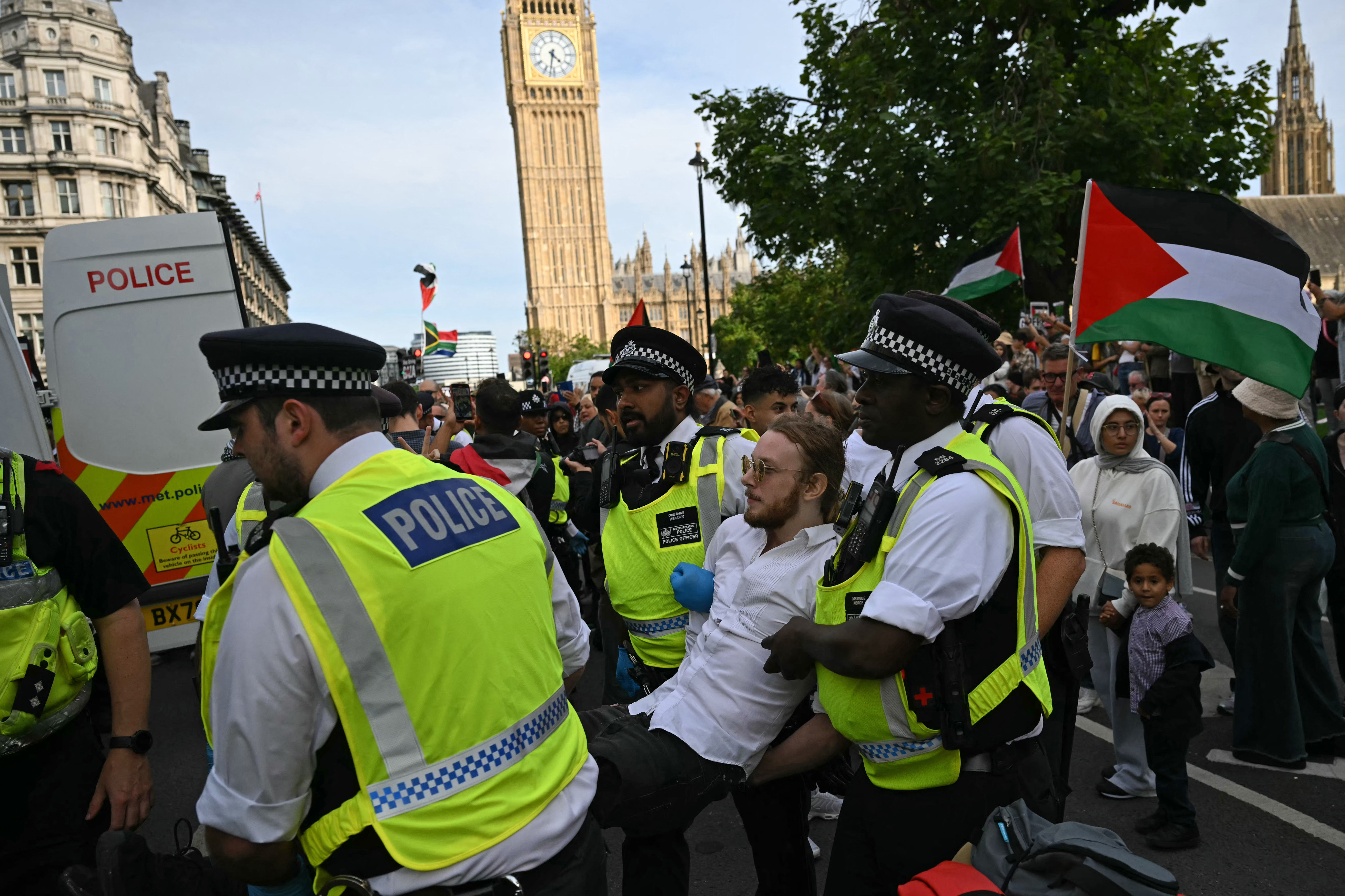 A protester is carried away by police officers at a "Lift The Ban"