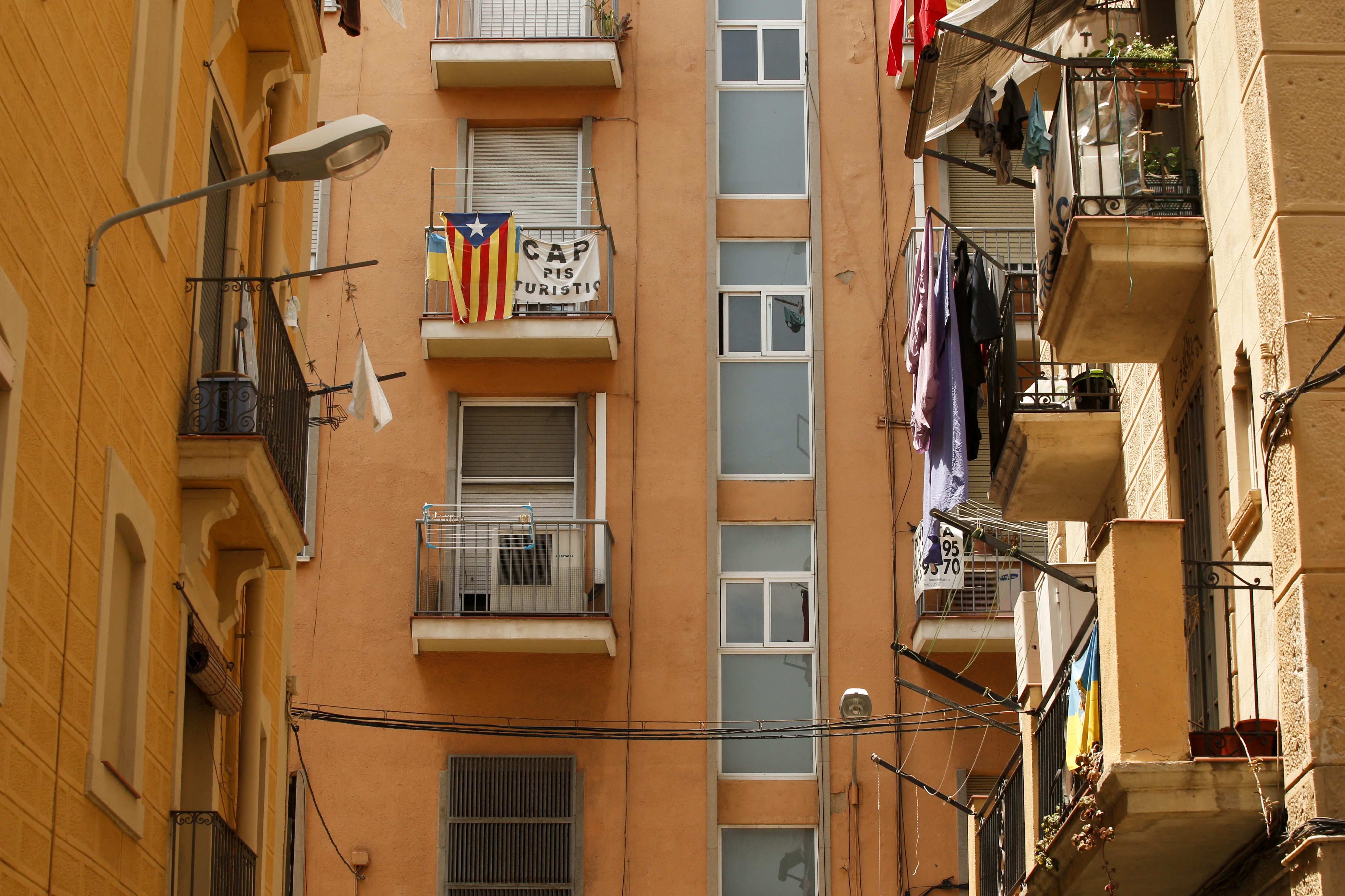 A banner reading "No tourist flats" hangs from a balcony to protest against holiday rental apartments for tourists in Barceloneta's, a neighborhood of Barcelona on June 10, 2016. (Photo by PAU BARRENA / AFP)