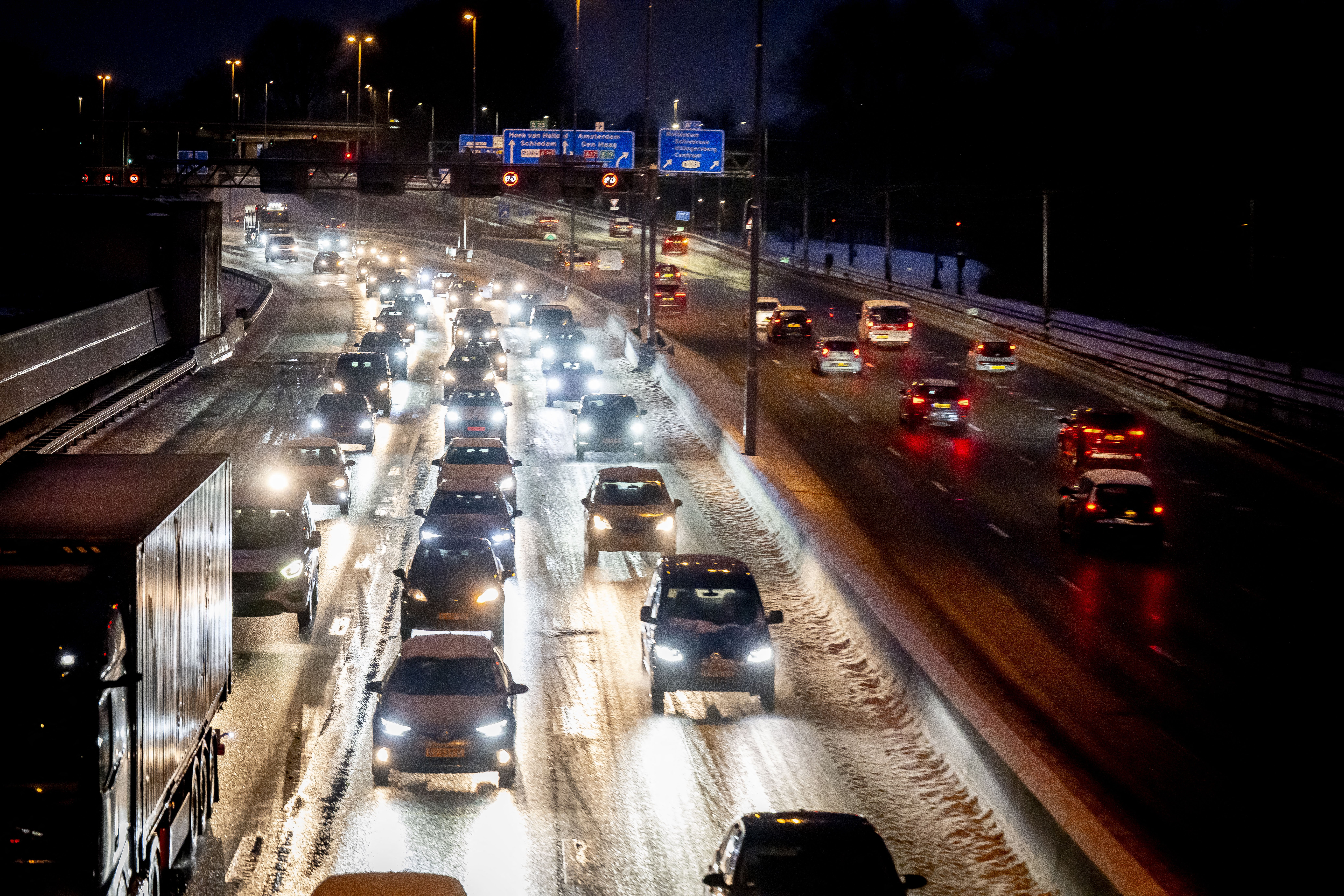 Motorists drive in traffic after snowfall during the morning rush hour on the A20 motowary near Rotterdam on January 5, 2026. A weather warning has been issued due to snow and slippery conditions. (Photo by Robin Utrecht / ANP / AFP) / Netherlands OUT
