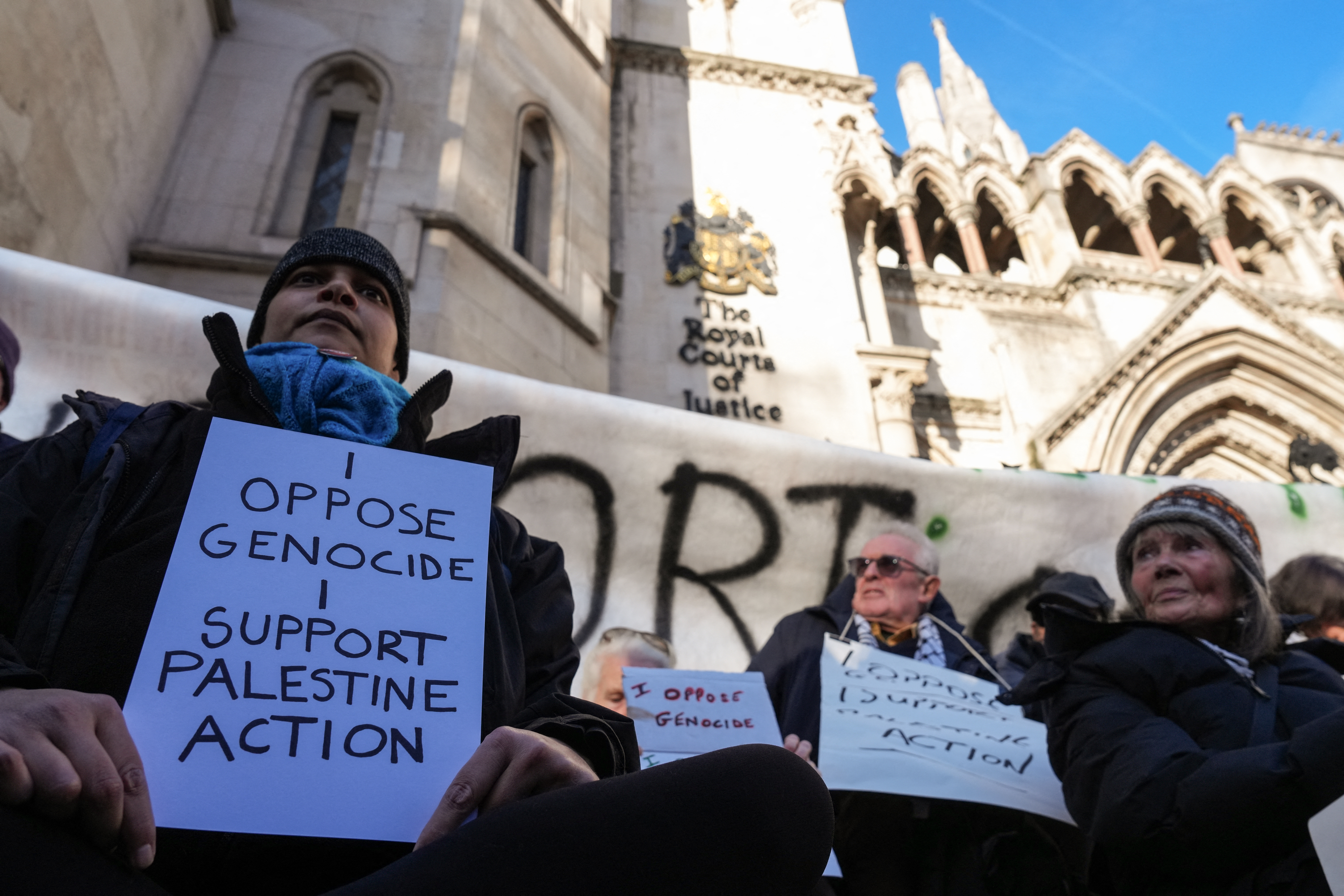 Protesters take part in a demonstration in support of "Defend Our Juries" and their campaign against the ban on Palestine Action, outside the Royal Courts of Justice, Britain's High Court, in central London on November 26, 2025.