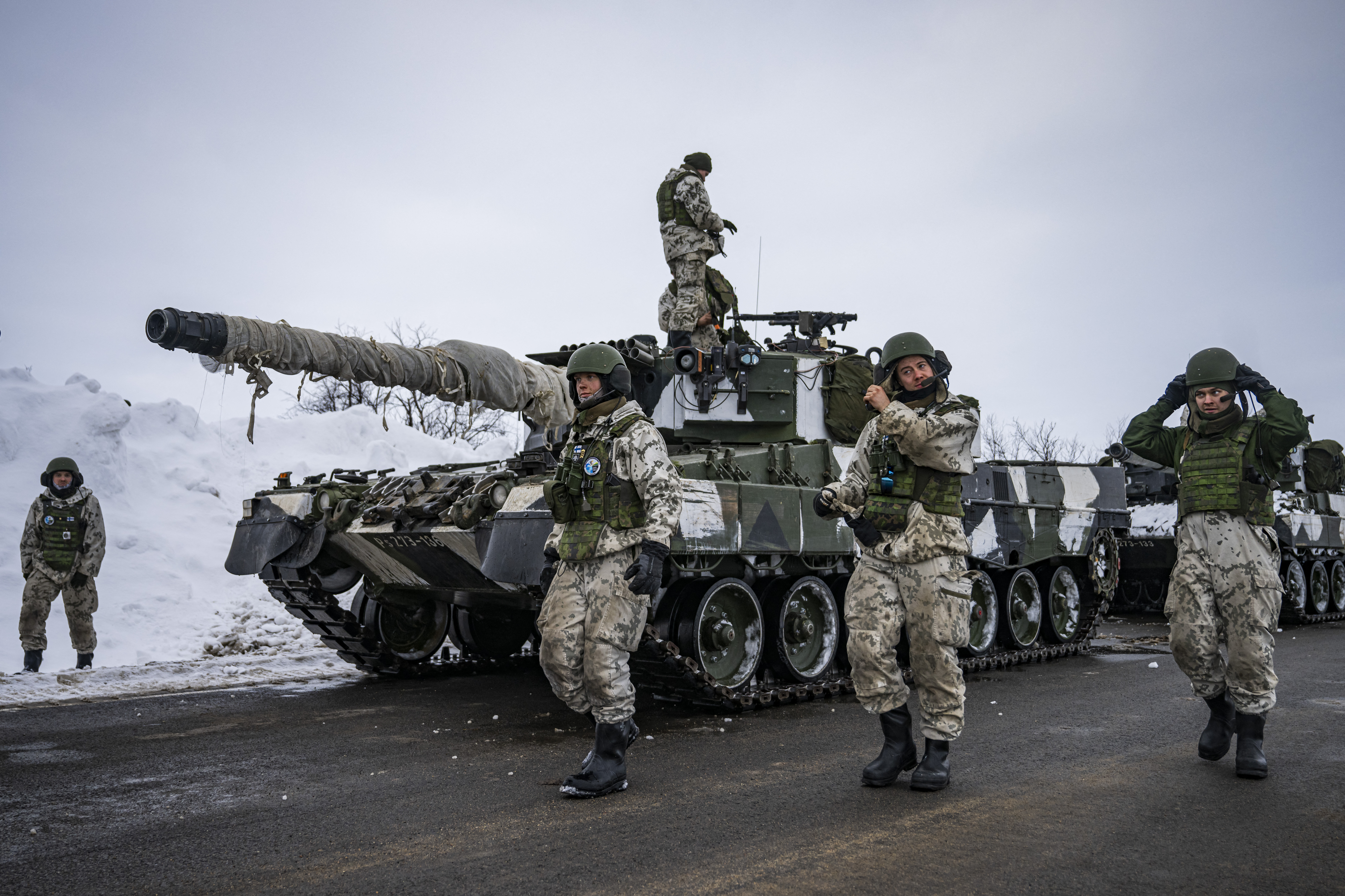Finnish soldiers of the Finnish-Swedish Devision walk next to the Leopard 2A6, a third generation German main battle tank, after a demonstration of border crossing by Swedish and Finnish troops