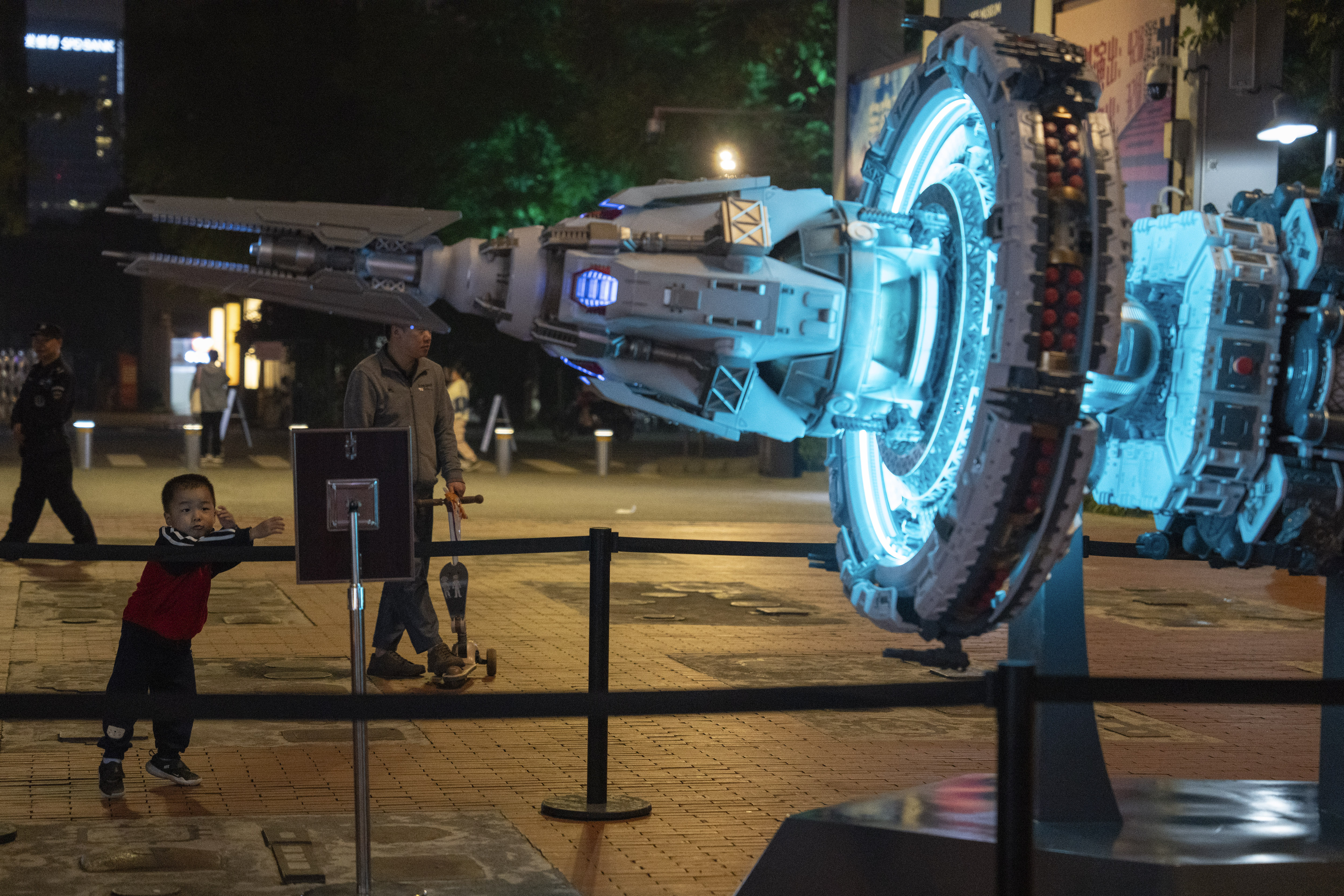 A child stands near a depiction of a space craft at an exhibition about "The Three-Body Problem" in Chengdu, Sichuan province on Friday, Oct. 20, 2023.