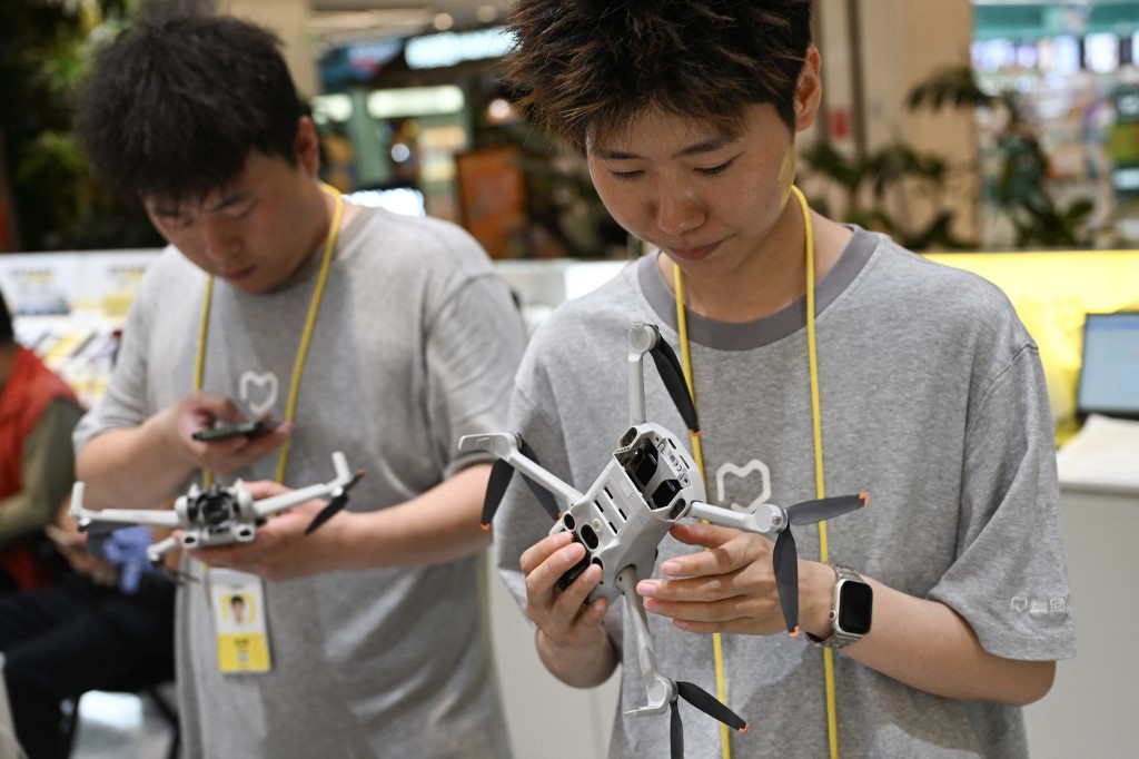 Employees at a drone reception module in a shopping mall inspect drones brought in by their owners in Beijing on September 16, 2026.