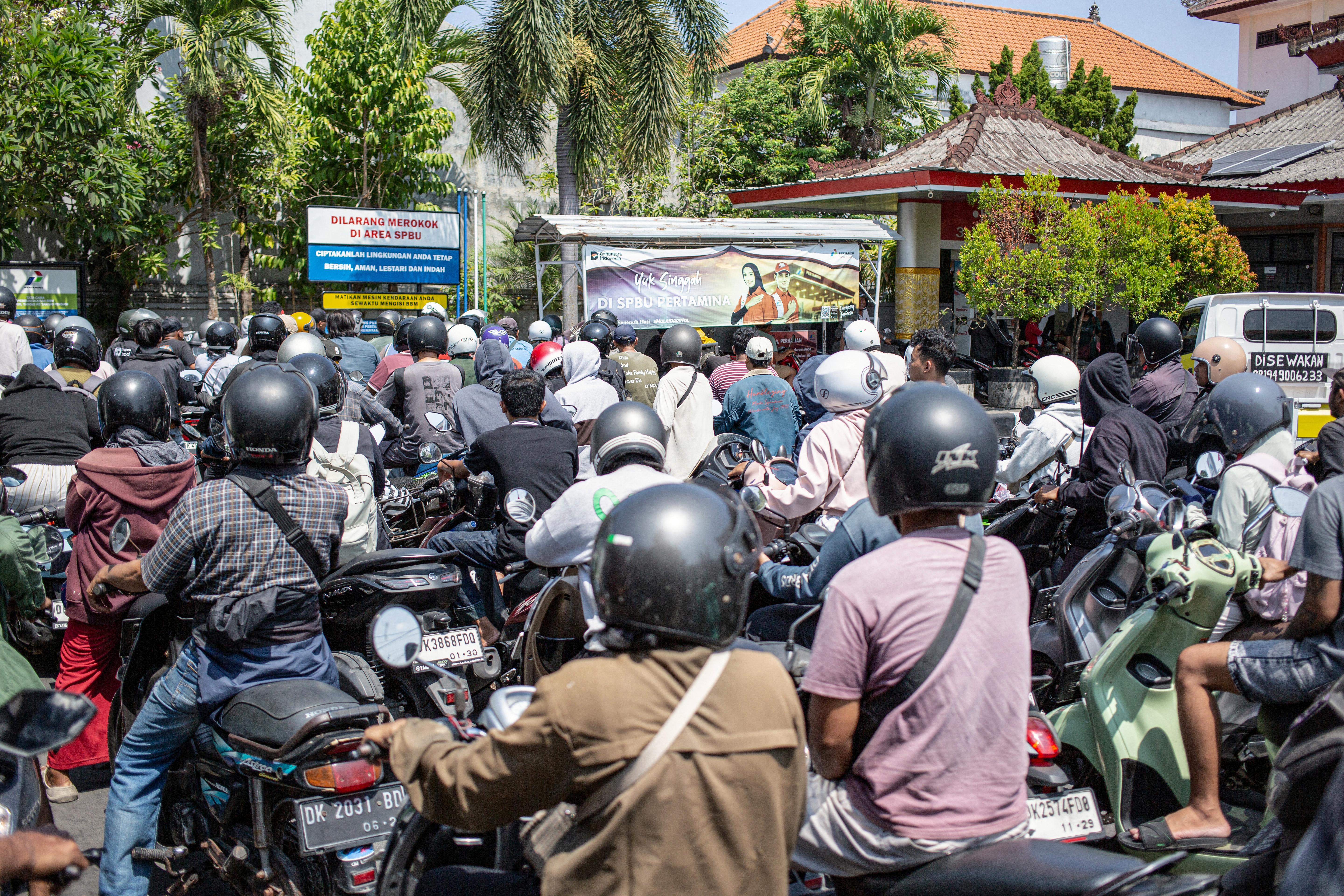 Motorcyclists queue to refuel at a gas station in Denpasar amid a fuel supply shortage on Indonesia's Bali island on October 13, 2026. (Photo by LANA PRIATNA / AFP)