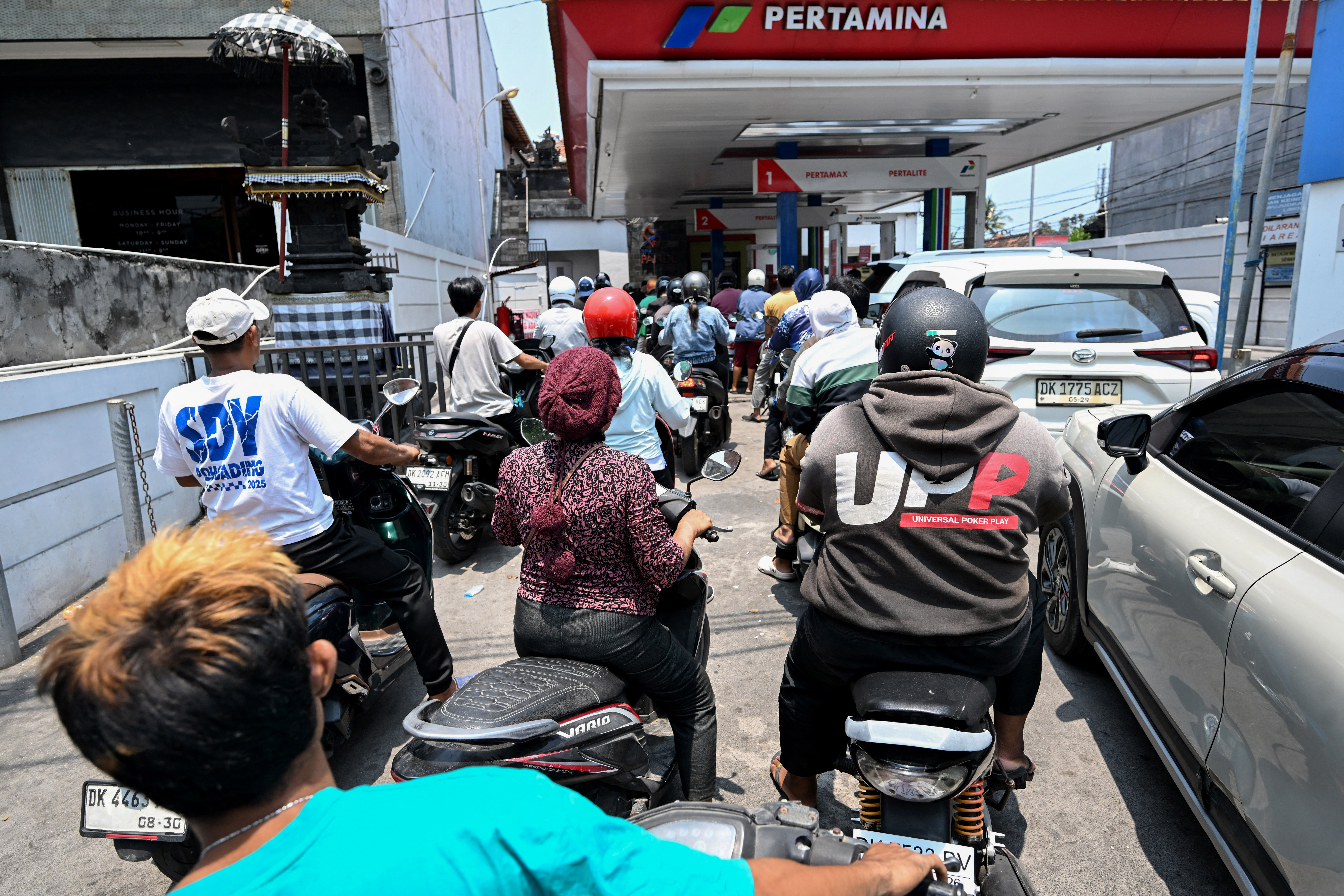 Motorcyclists queue to refuel at a gas station in Denpasar amid a fuel supply shortage on Indonesia's resort island of Bali on October 14, 2026. (Photo by SONNY TUMBELAKA / AFP)