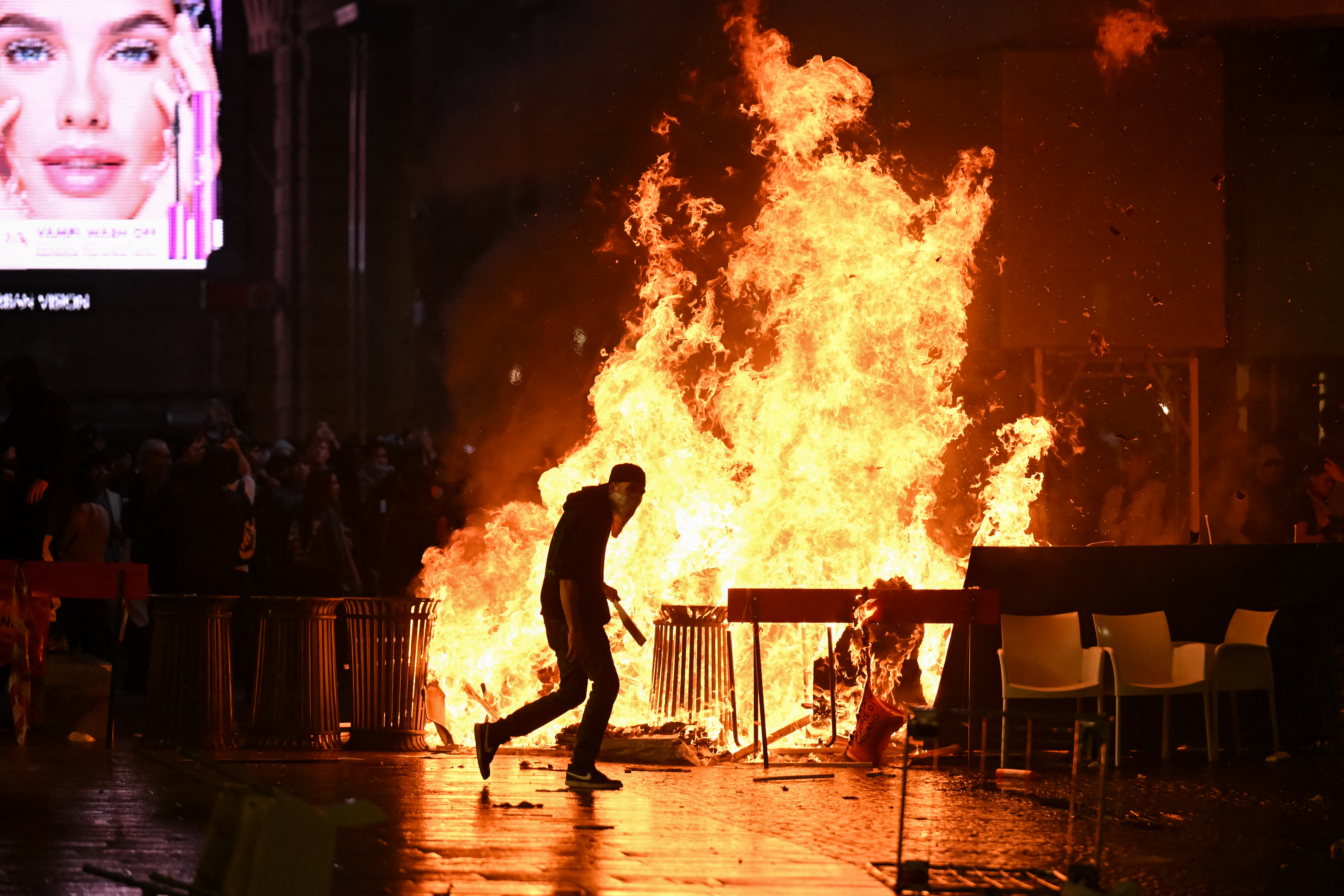 A barricade of cardboards and trash is set on fire as demonstrators clash with Police during an anti-government protest organized by the Italia in Piazza movement, at Piazza Duomo in Milan, on October 17, 2026.