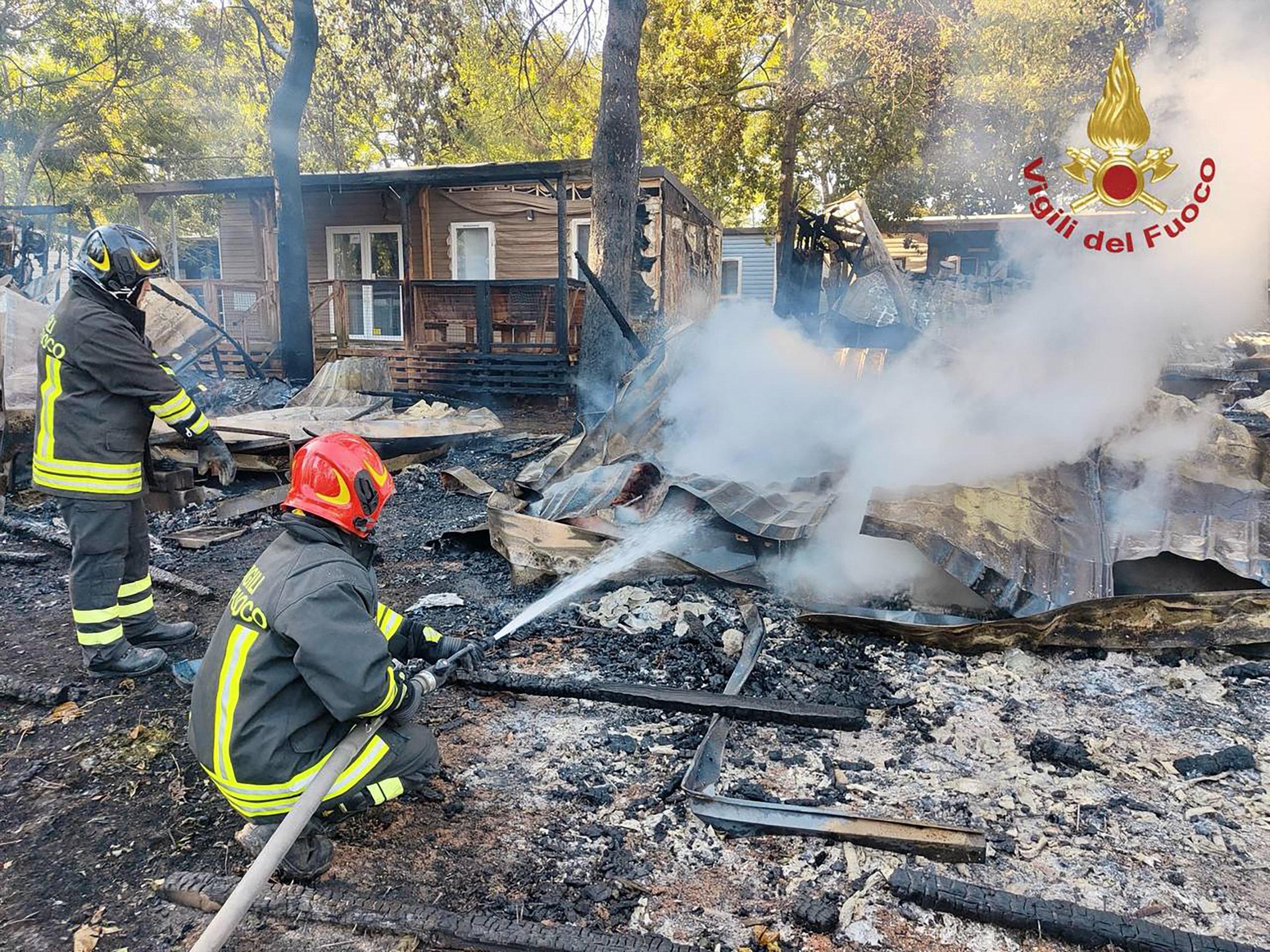 This photo taken and handout on October 4, 2026 by the Vigili del Fuoco, the Italian Corps. of Firefighters, shows firefighters extinguishing a fire that broke out at "Bella Italia", a large camp site in Peschiera del Garda on Lake Garda, northern Italy.