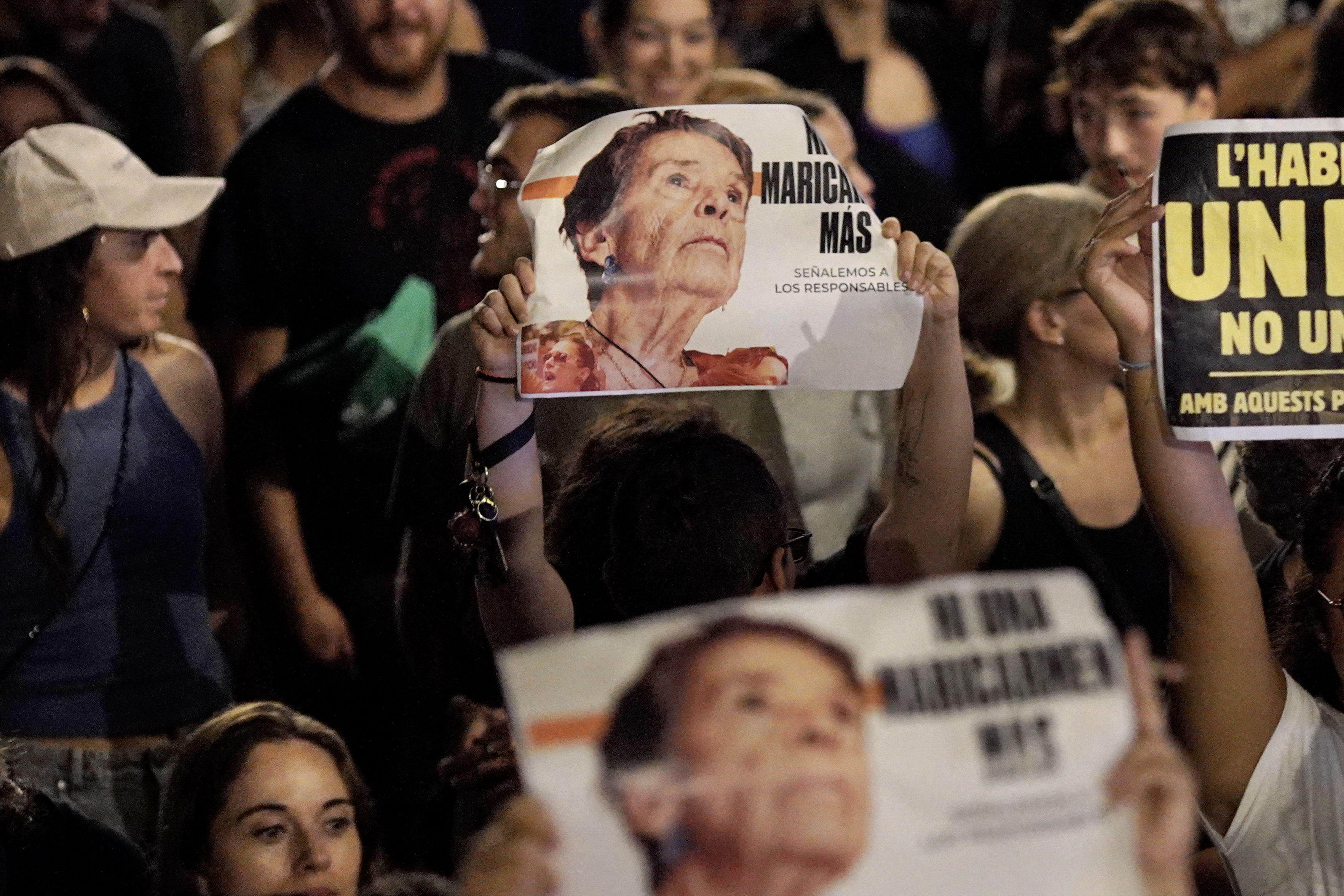 (FILES) Demonstrators hold signs reading 'Not a single more Maricarmen' in a reference to Maricarmen Abascal, an 87-year-old pensioner evicted from her Madrid home, during a protest against evictions and high rent prices on plaza Tetuan in Barcelona