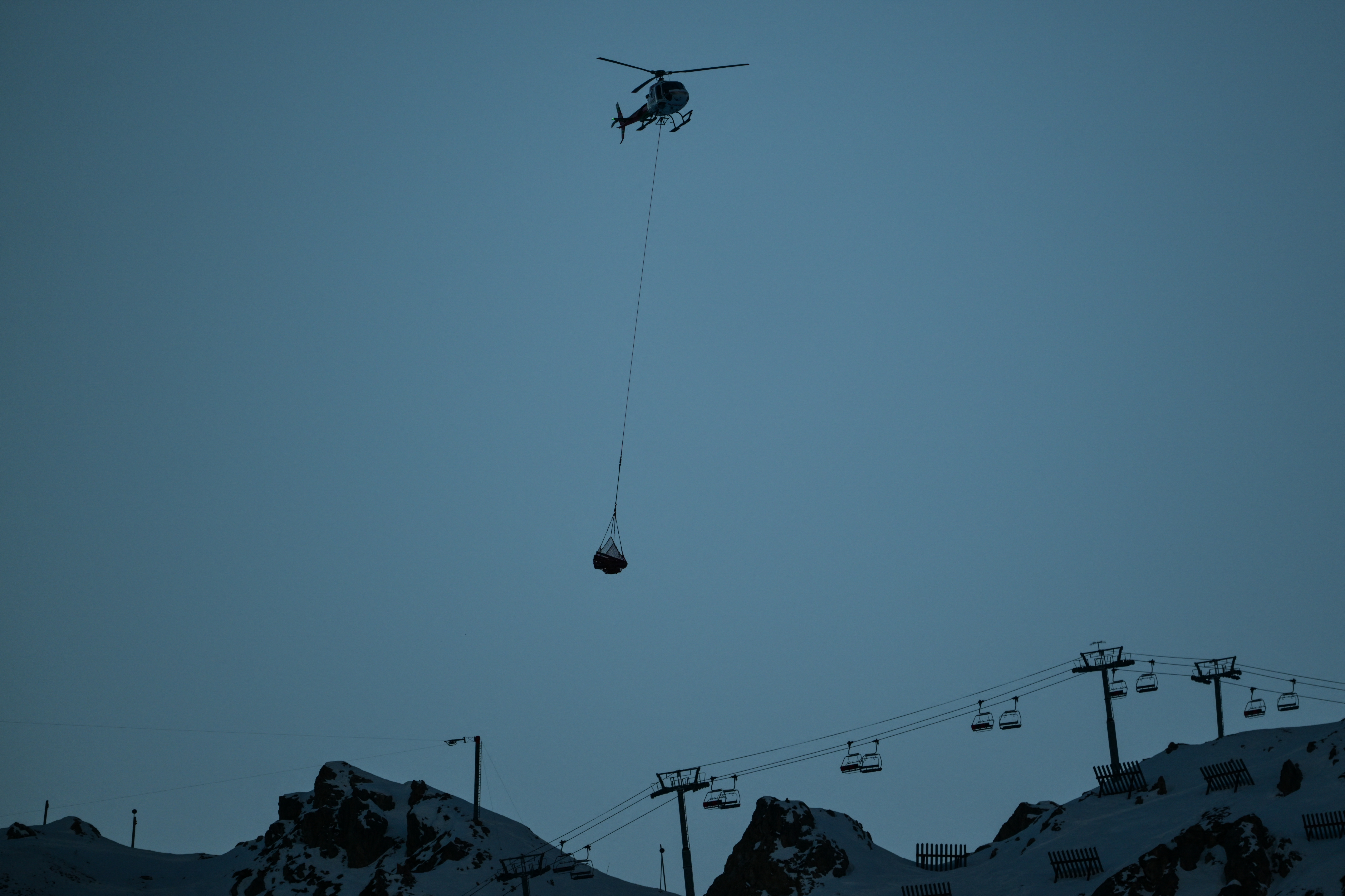 A chopper flies over Val-d’Isere, in the French Alps on December 13, 2025