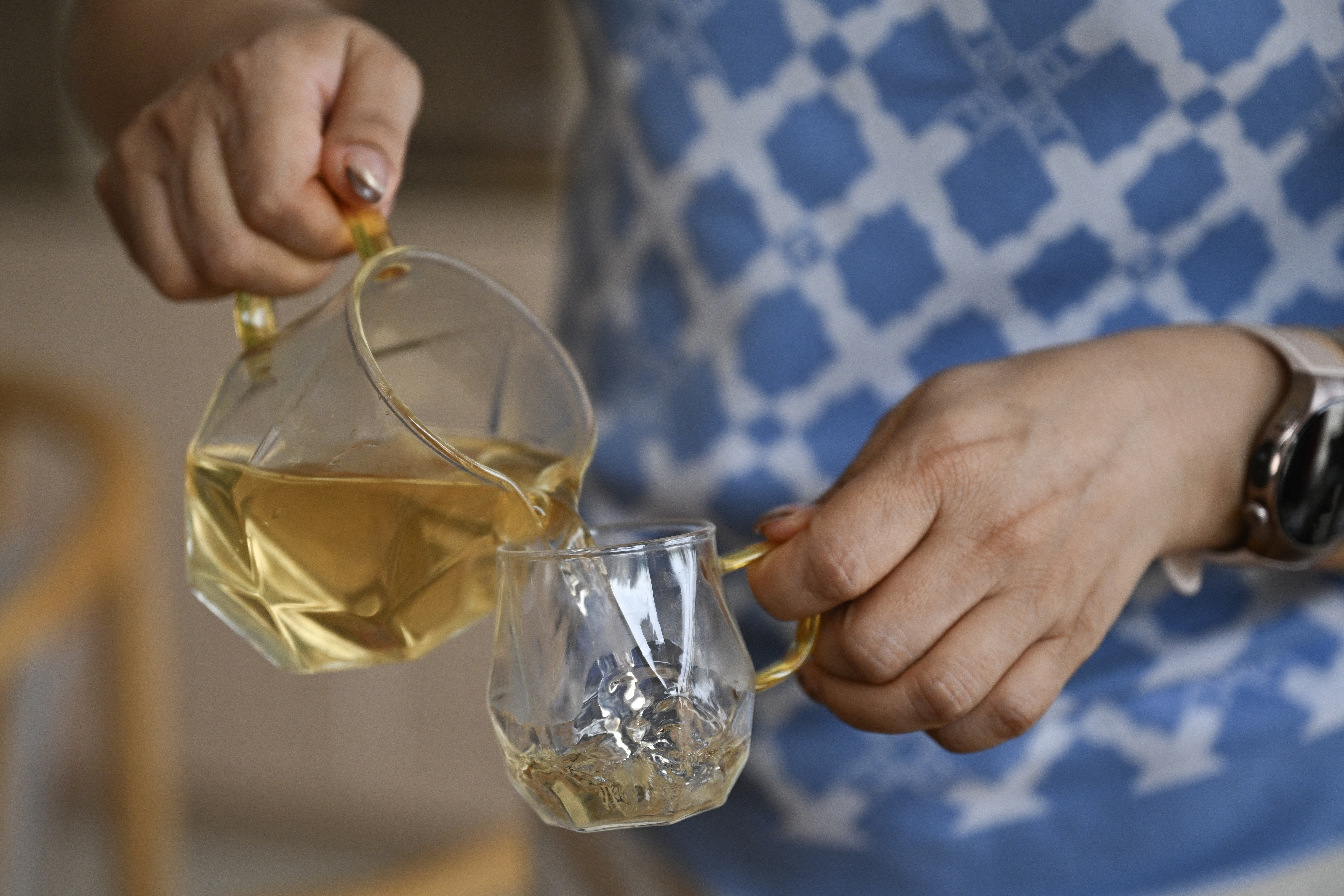This picture was taken on August 12, 2025 shows Bai Lei, owner of a traditional Chinese medicine store serving Cistanche tea in Dengkou County, Bayannur Prefecture, in China's northern Inner Mongolia region