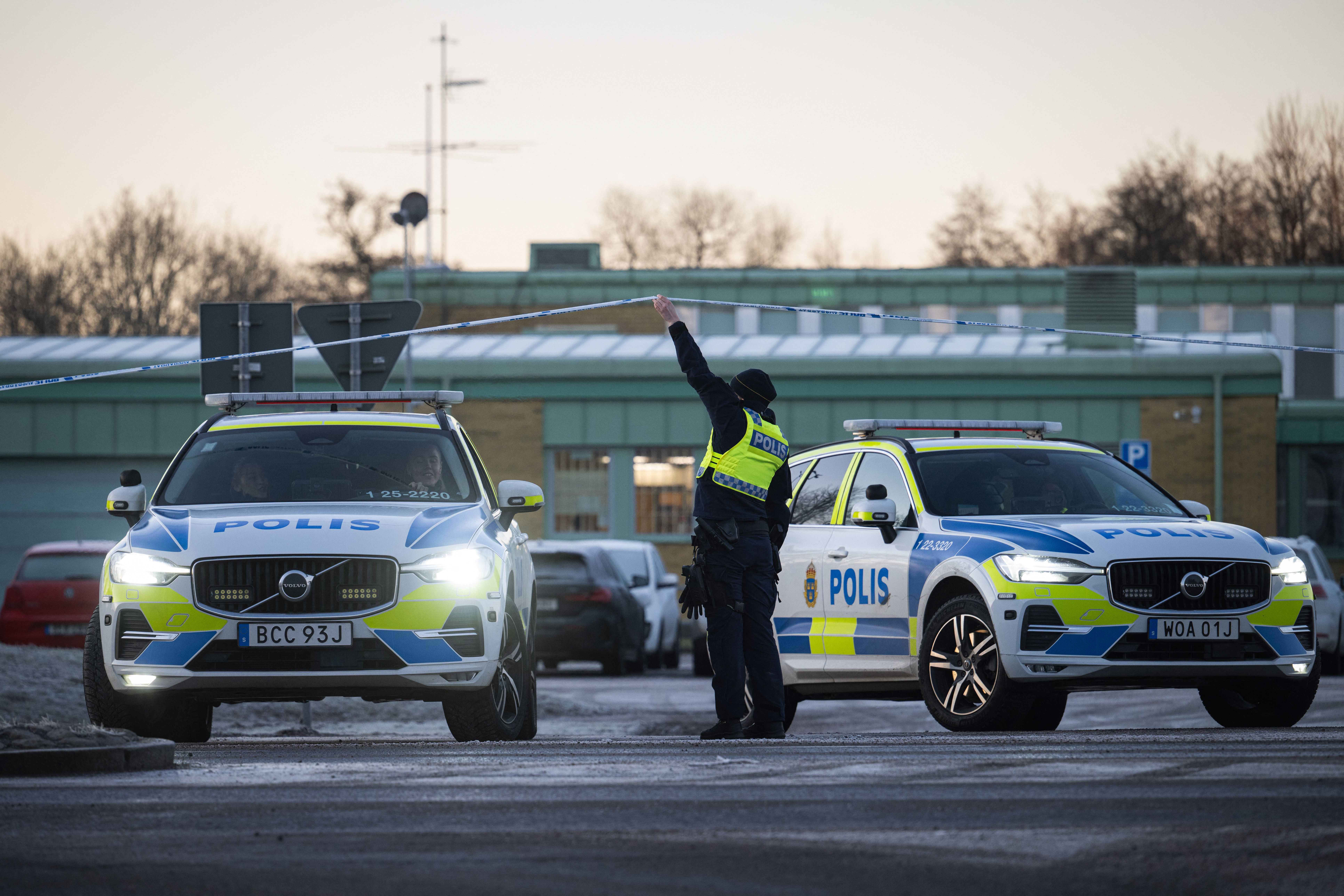 Police officers stand guard outside the adult education center Campus Risbergska. (Photo by Jonathan NACKSTRAND / AFP)