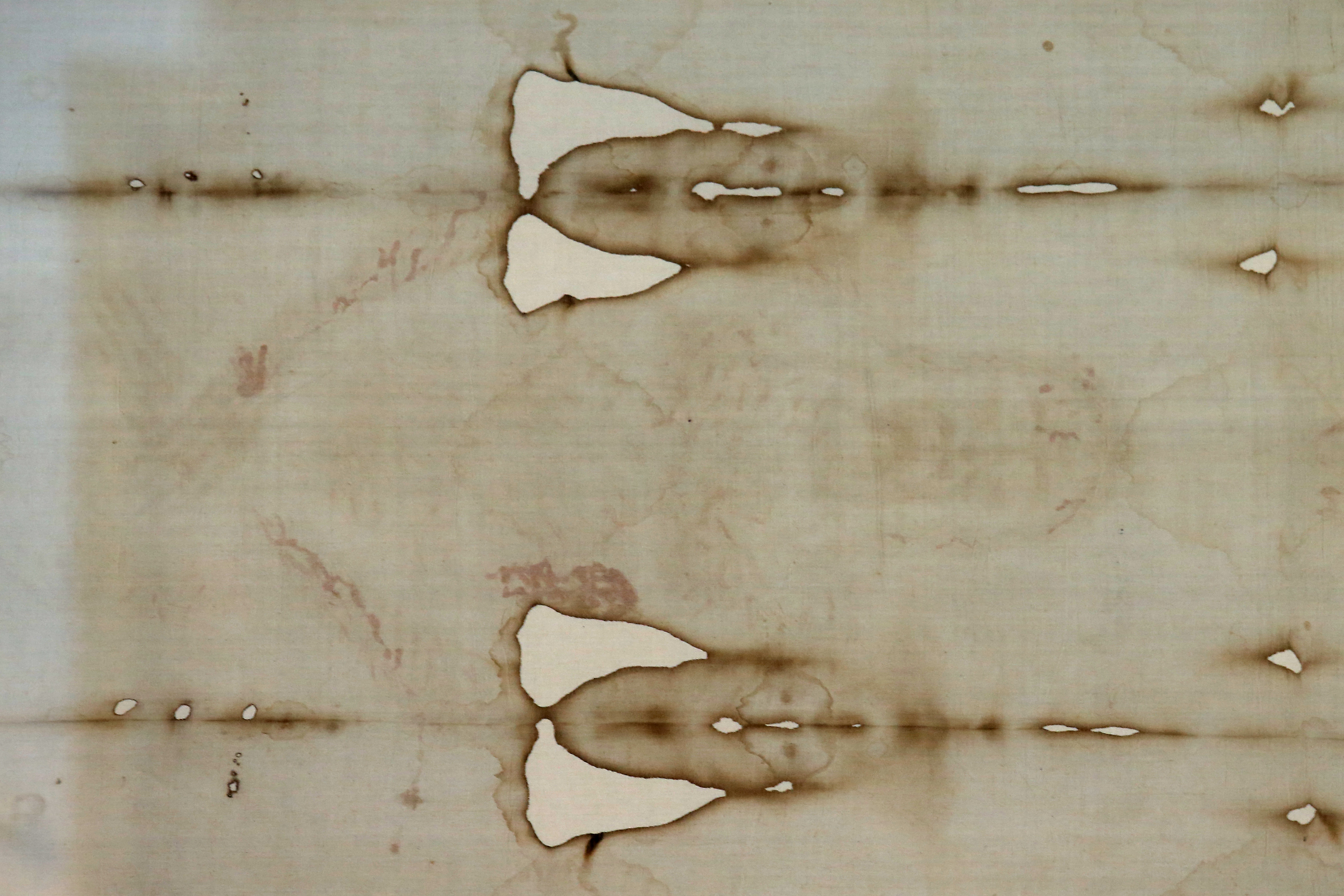 A picture shows a detail of the Shroud (Photo by MARCO BERTORELLO / AFP)